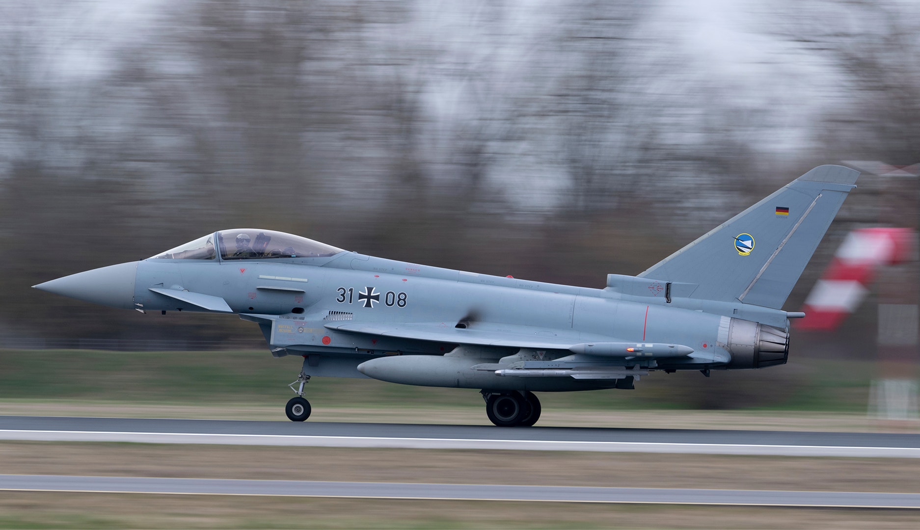 En grå Eurofighter Typhoon jaktflygplan med tysk markering på landningsbanan.
