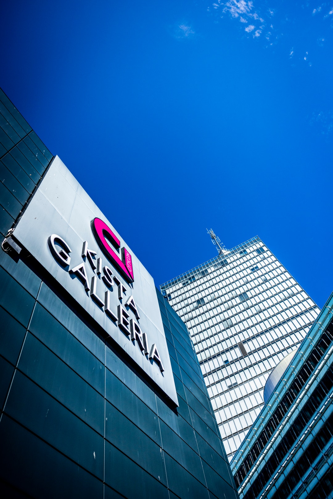 Kista-skylt på en byggnadsfasad med moderna kontorsbyggnader och blå himmel i bakgrunden