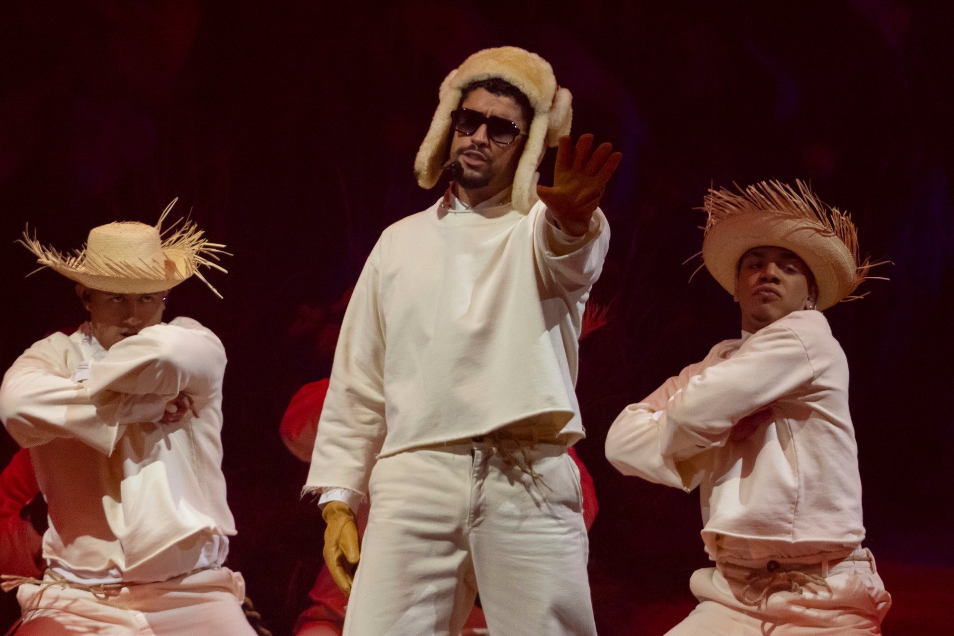 Bad Bunny är en puertoricansk sångare, rappare och låtskrivare står på scenen i Puerto Rico klädd i vitt framför två dansare som också är vitklädda.