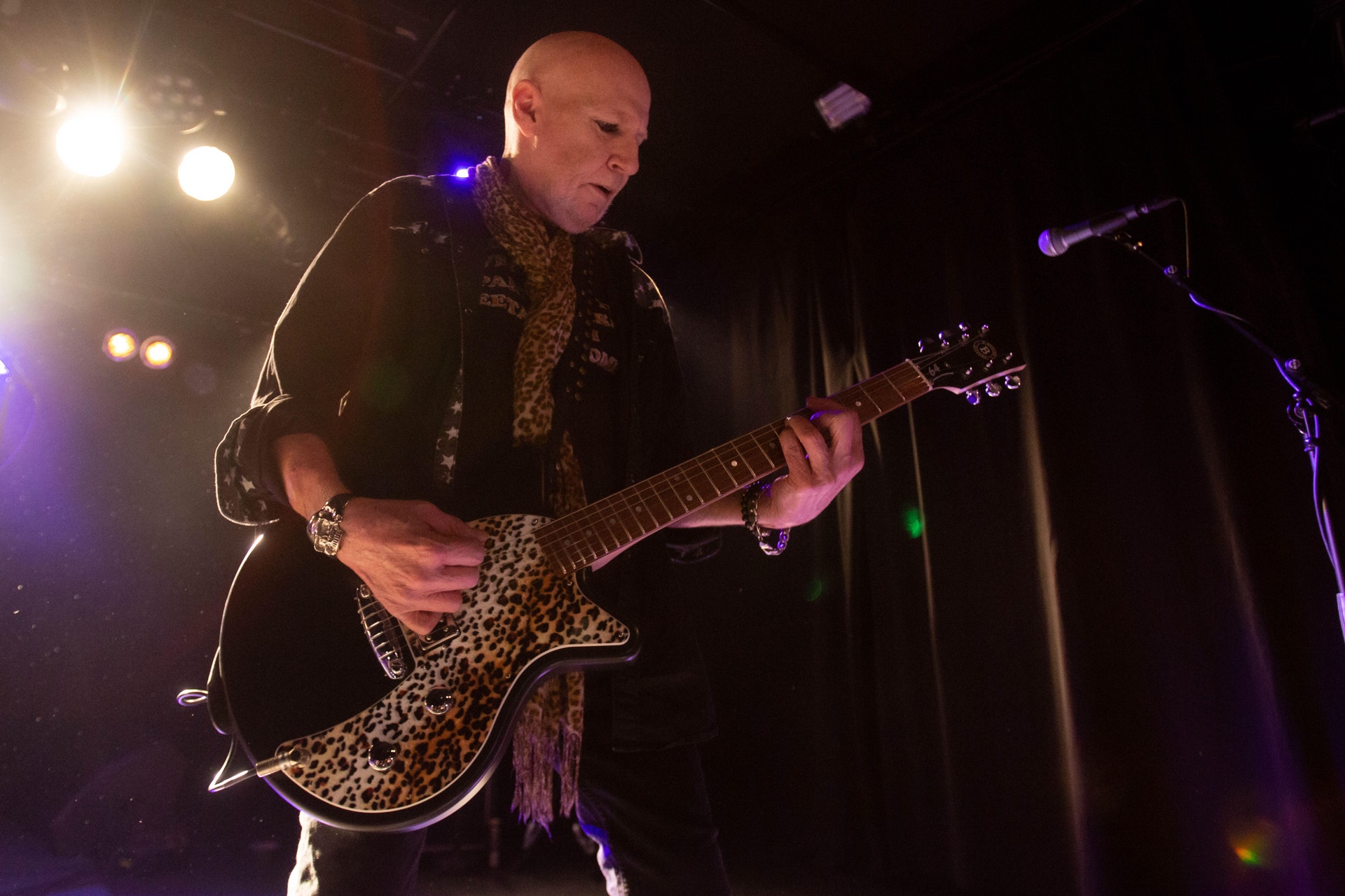 En man spelar elgitarr på en scen.