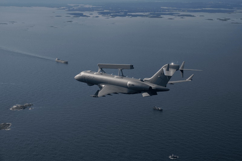 Militärt övervakningsflygplan flyger över havet med fartyg synliga under sig.