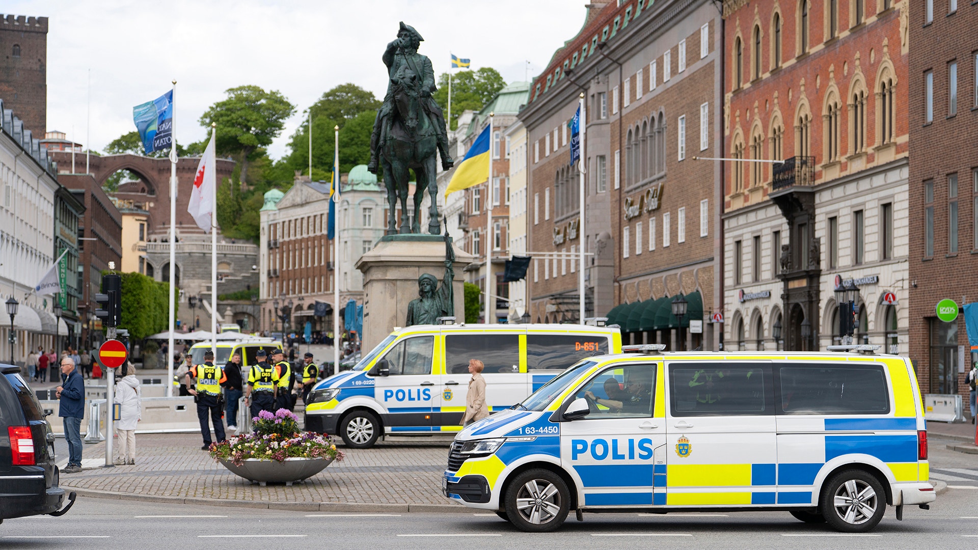 Helsingborgs torg under Natomötet med polisbilar, poliser och en ryttarstaty omgiven av historiska byggnader.