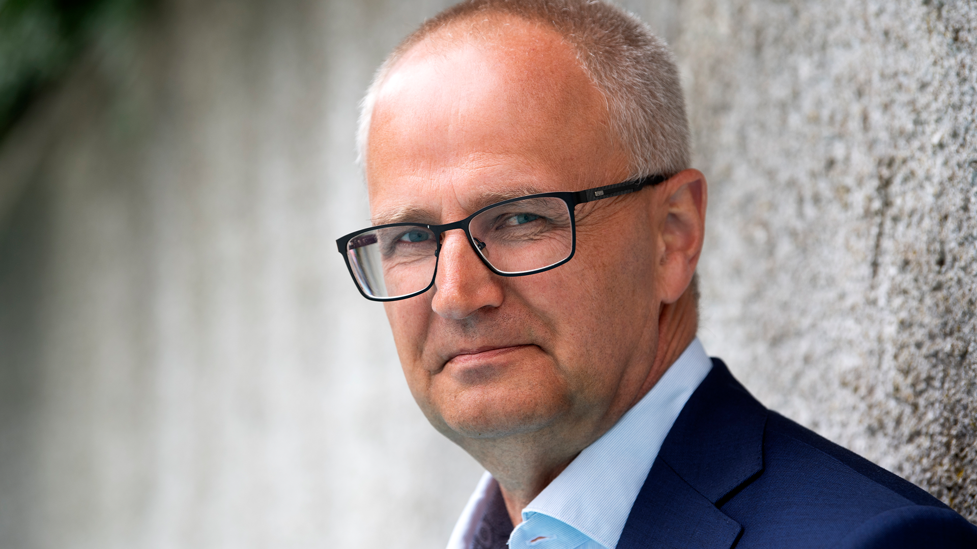 Porträttfoto av en man med glasögon i professionell kläder