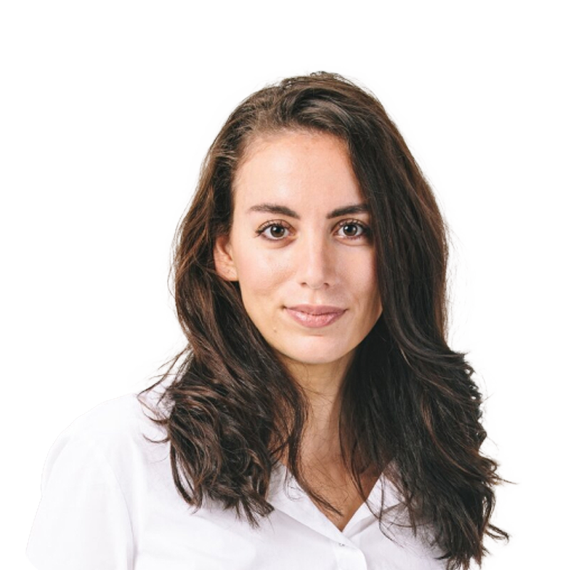 Porträttfoto av en kvinna med långt mörkt hår, klädd i vit skjorta mot vit bakgrund.