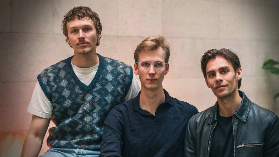 Porträtt av tre män som står tillsammans och tittar mot kameran.