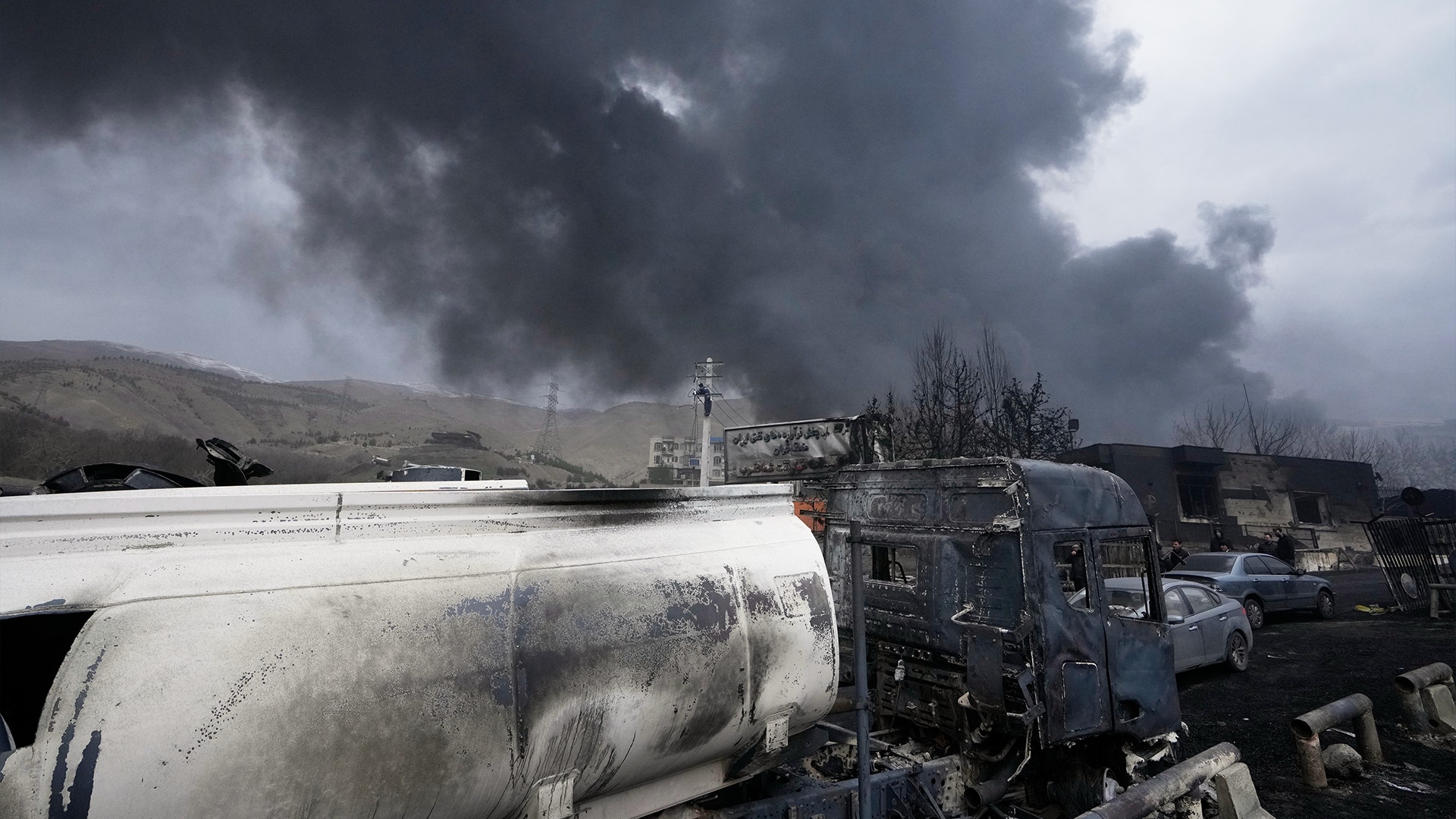 Skadade fordon och rök från explosioner i industriell miljö