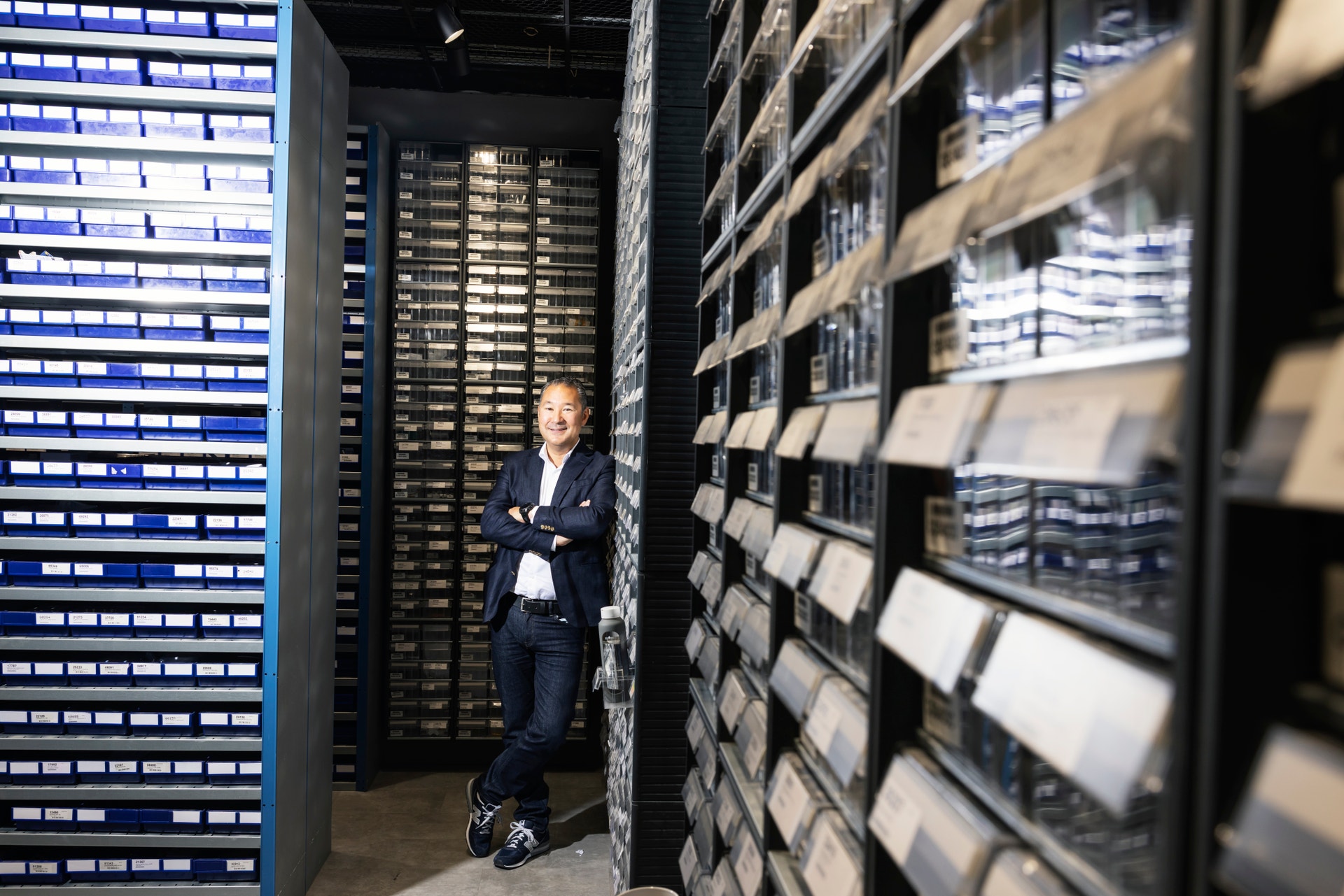 En person i mörk kostym står i ett serverrum omgiven av stora rack med servrar och teknisk utrustning.