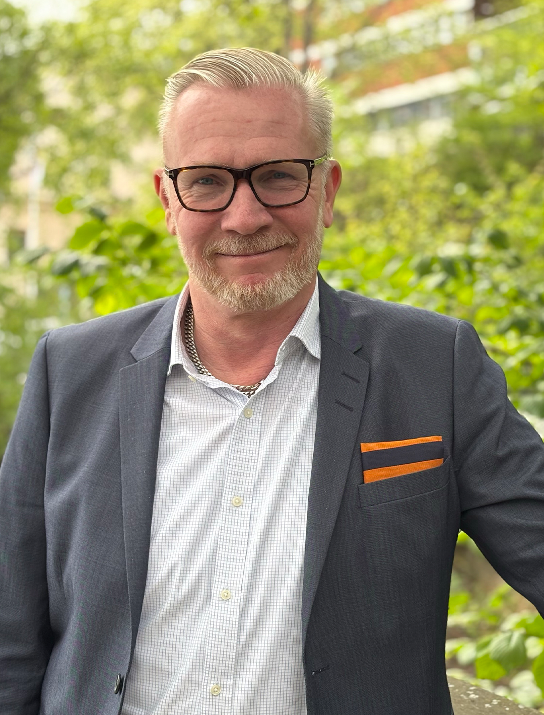 Mats Hedenström står klädd i kostym när han poserar längs en löparbana i Stockholm