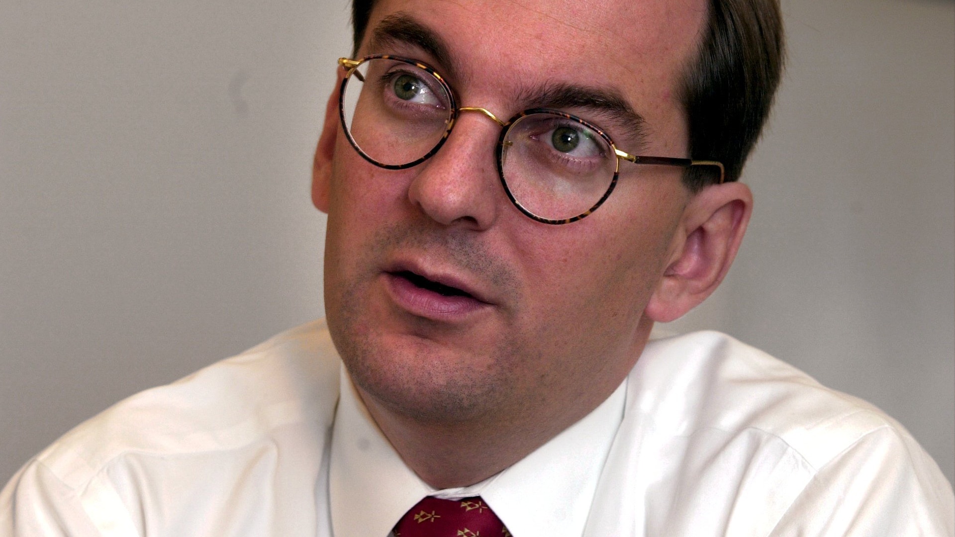 Porträtt av en man med glasögon och vit skjorta