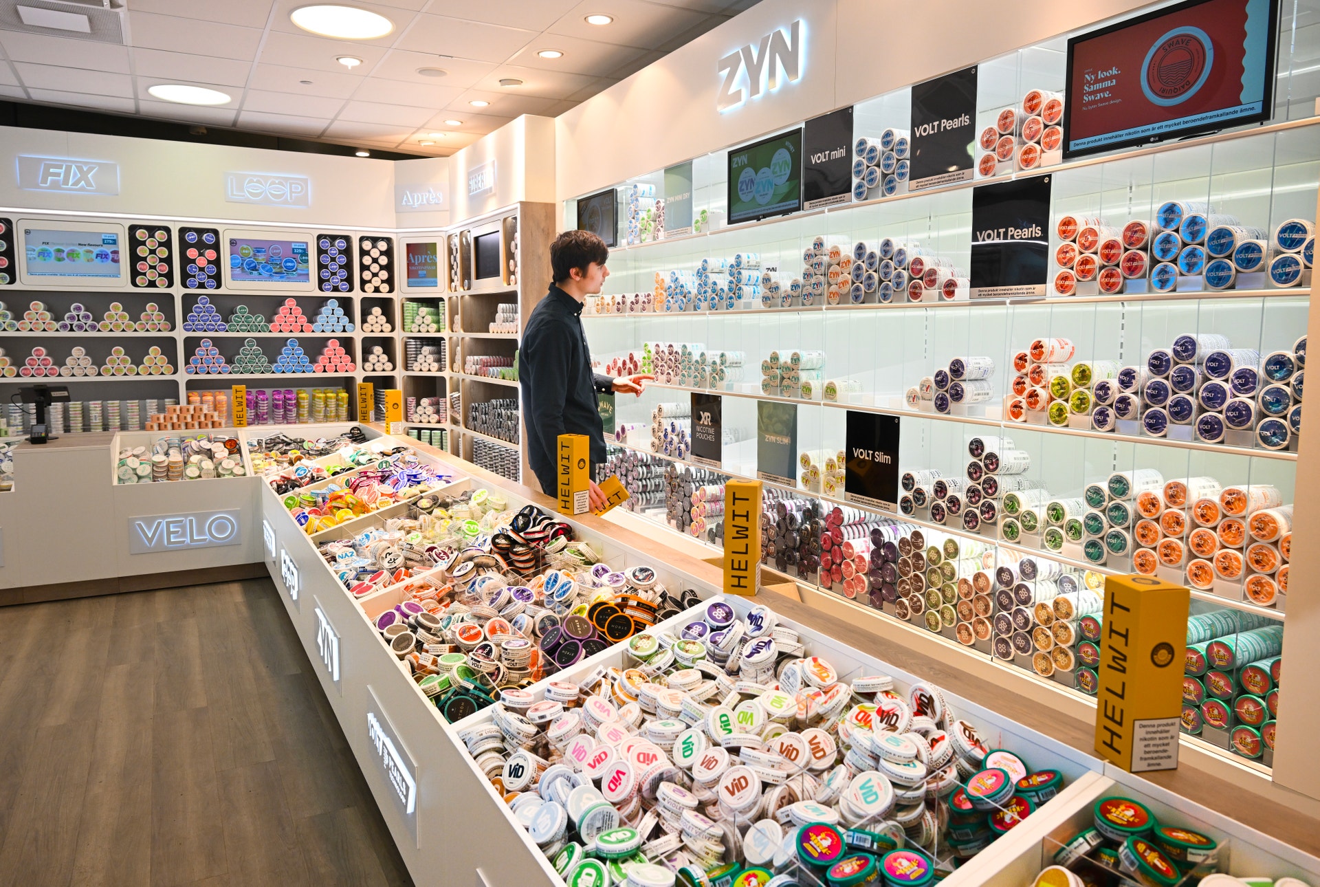 En butik med väggmonterade hyllor och en försäljningsdisk fylld med färgglada dekorativa tejper och tillbehör.