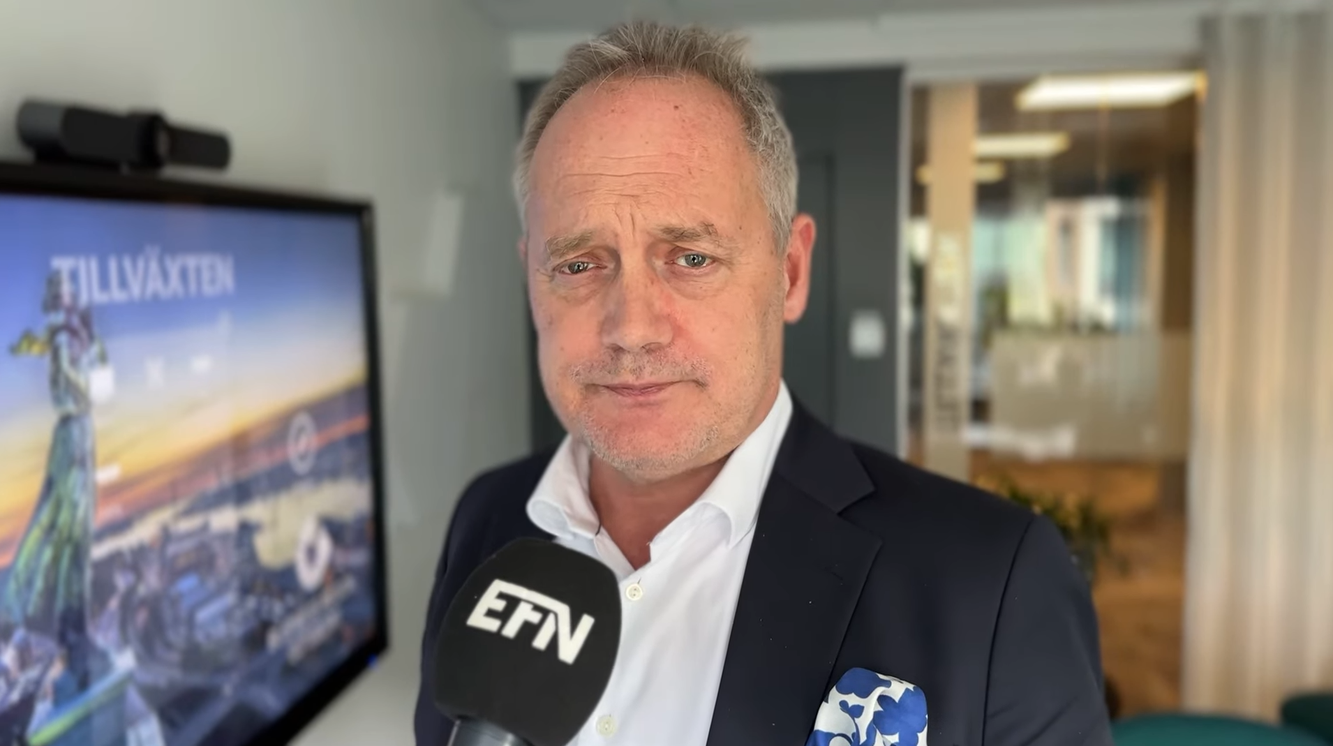 Porträttfoto av en man i mörk blazer och vit skjorta