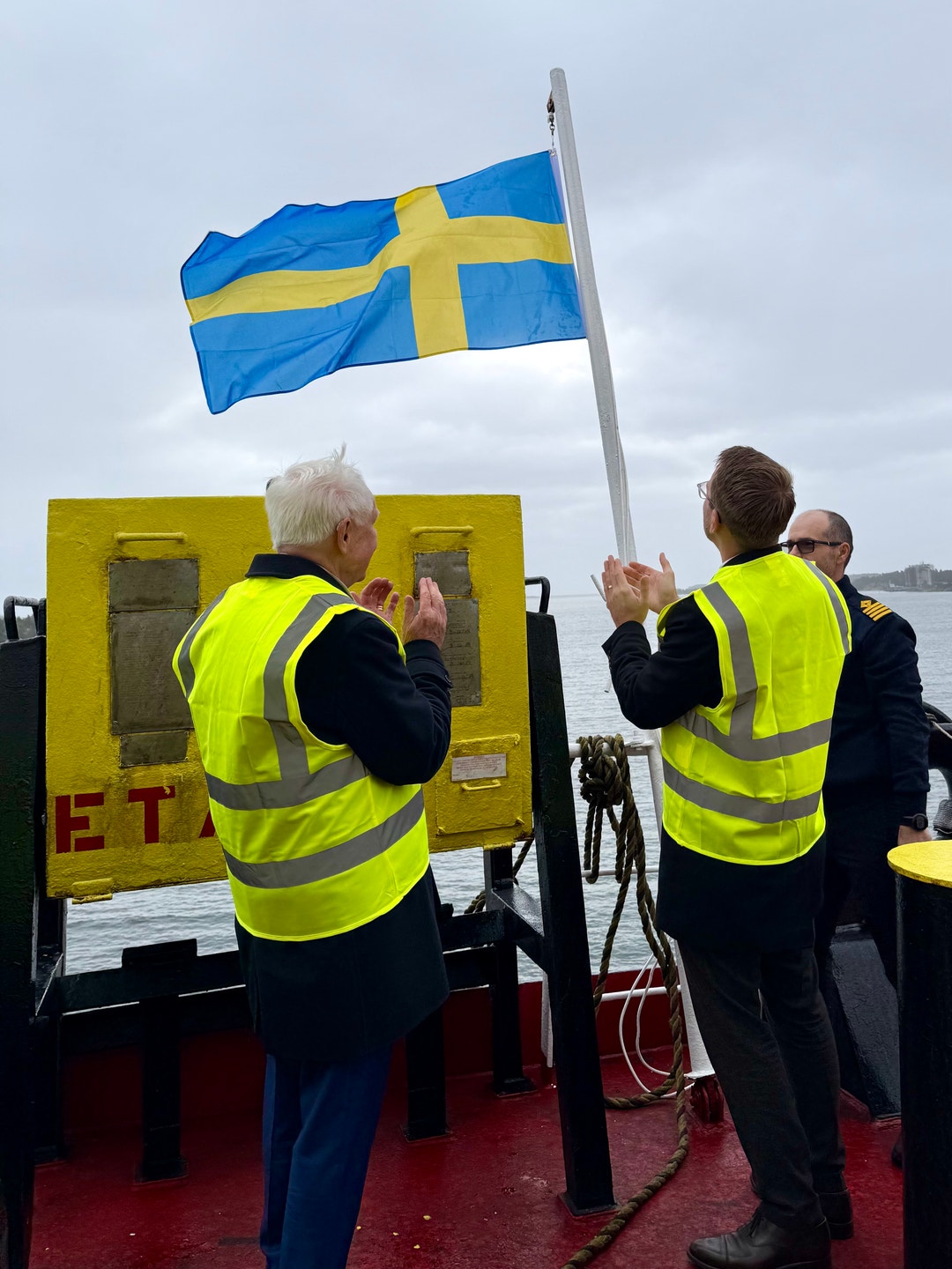Dan Sten Olsson och Andreas Carlsson hissar svensk flagg