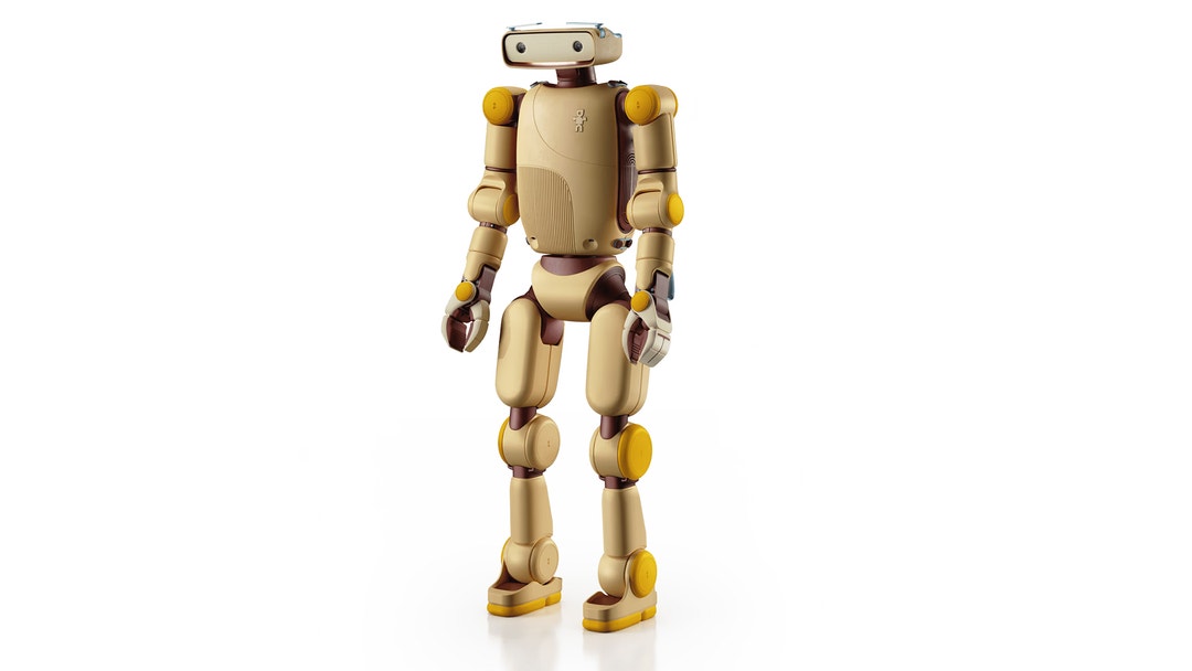 En beige och guldigt färgad humanoid robot med ledade armar och ben står på vit bakgrund.