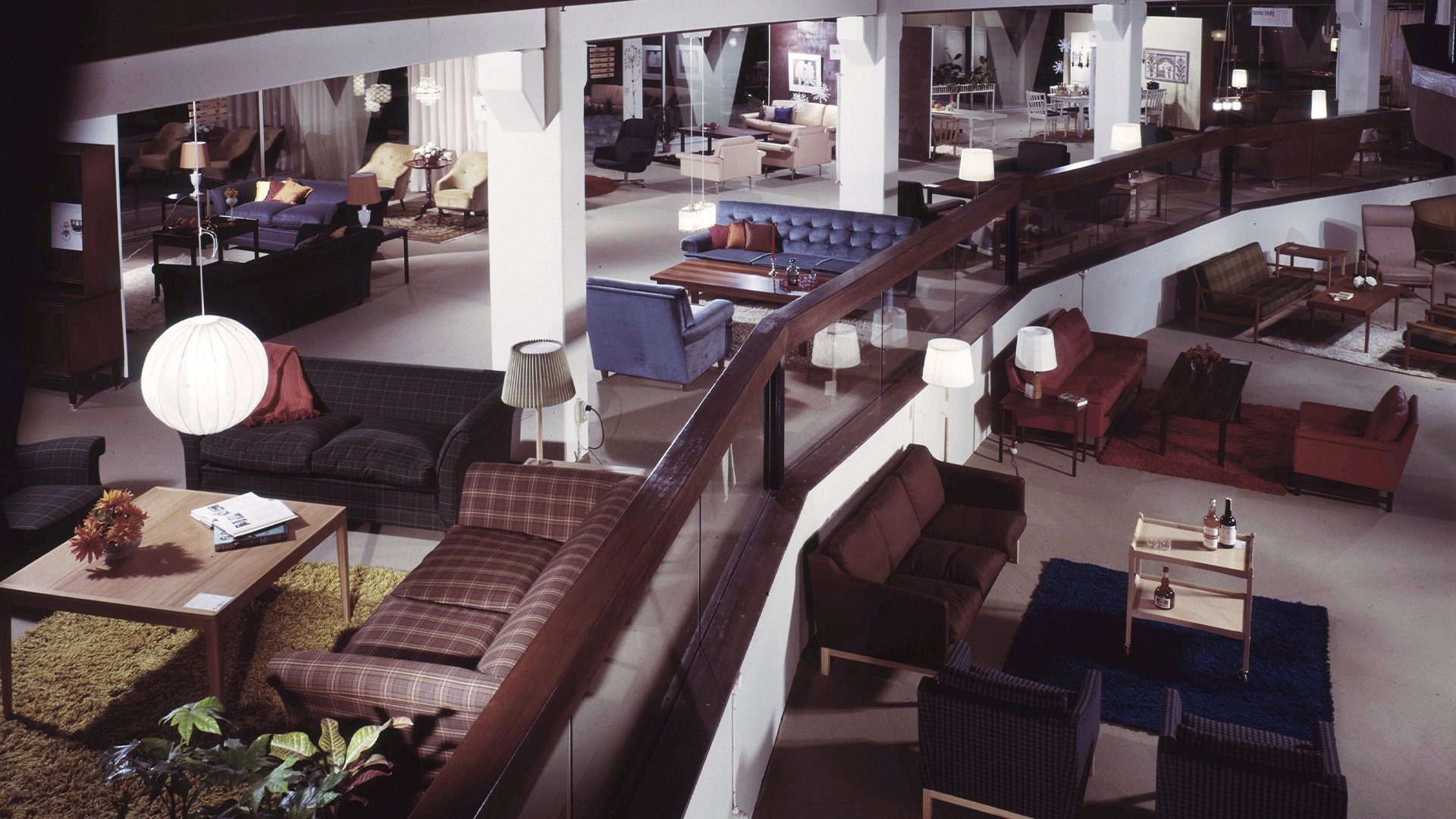 Möbelutställning med olika sitsmöbler och inredningselement arrangerade i ett modernt showroom
