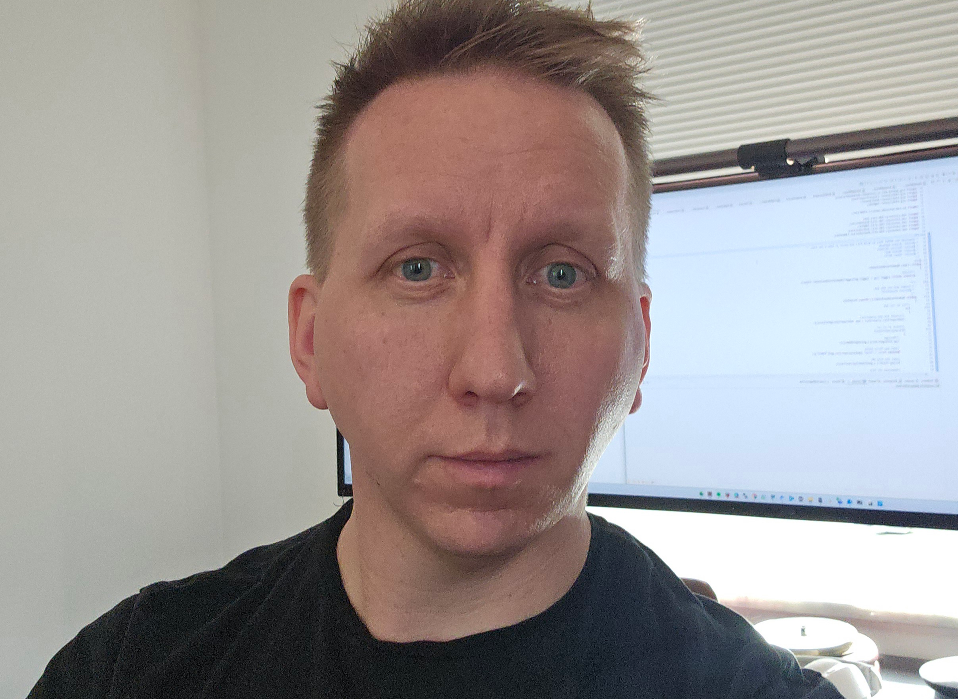 Porträtt av en man i svart skjorta i ett kontorsrum