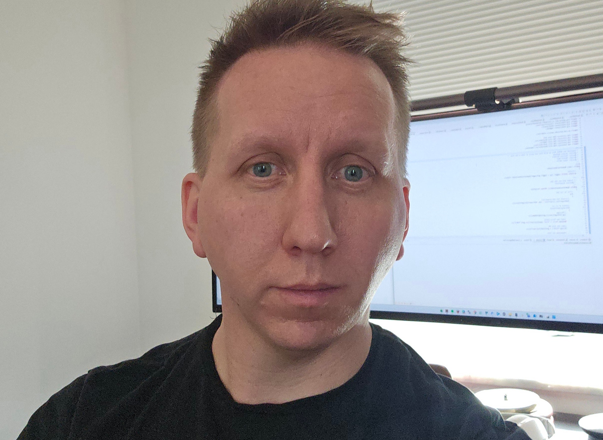 Porträtt av en man i svart skjorta i ett kontorsrum