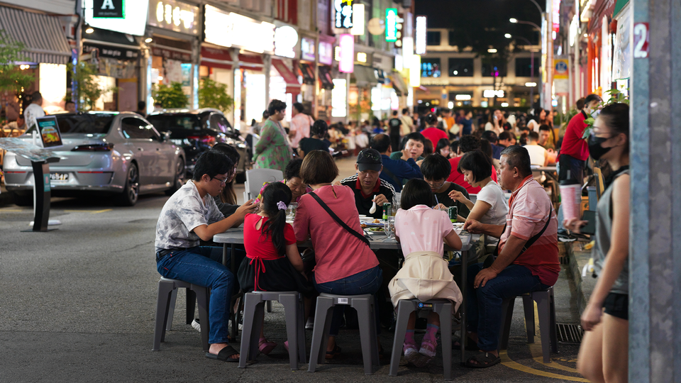 Personer äter middag på gatorna i Singapore. 
