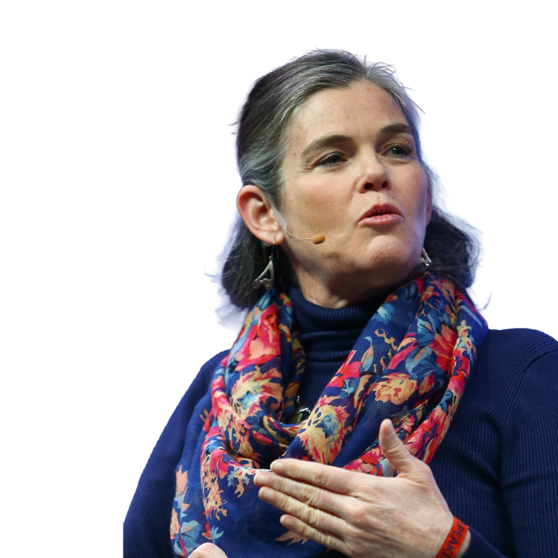 Porträttfoto av en kvinna med mörkt hår som bär en marinblå tröja och ett färgglatt mönstrat scarf.