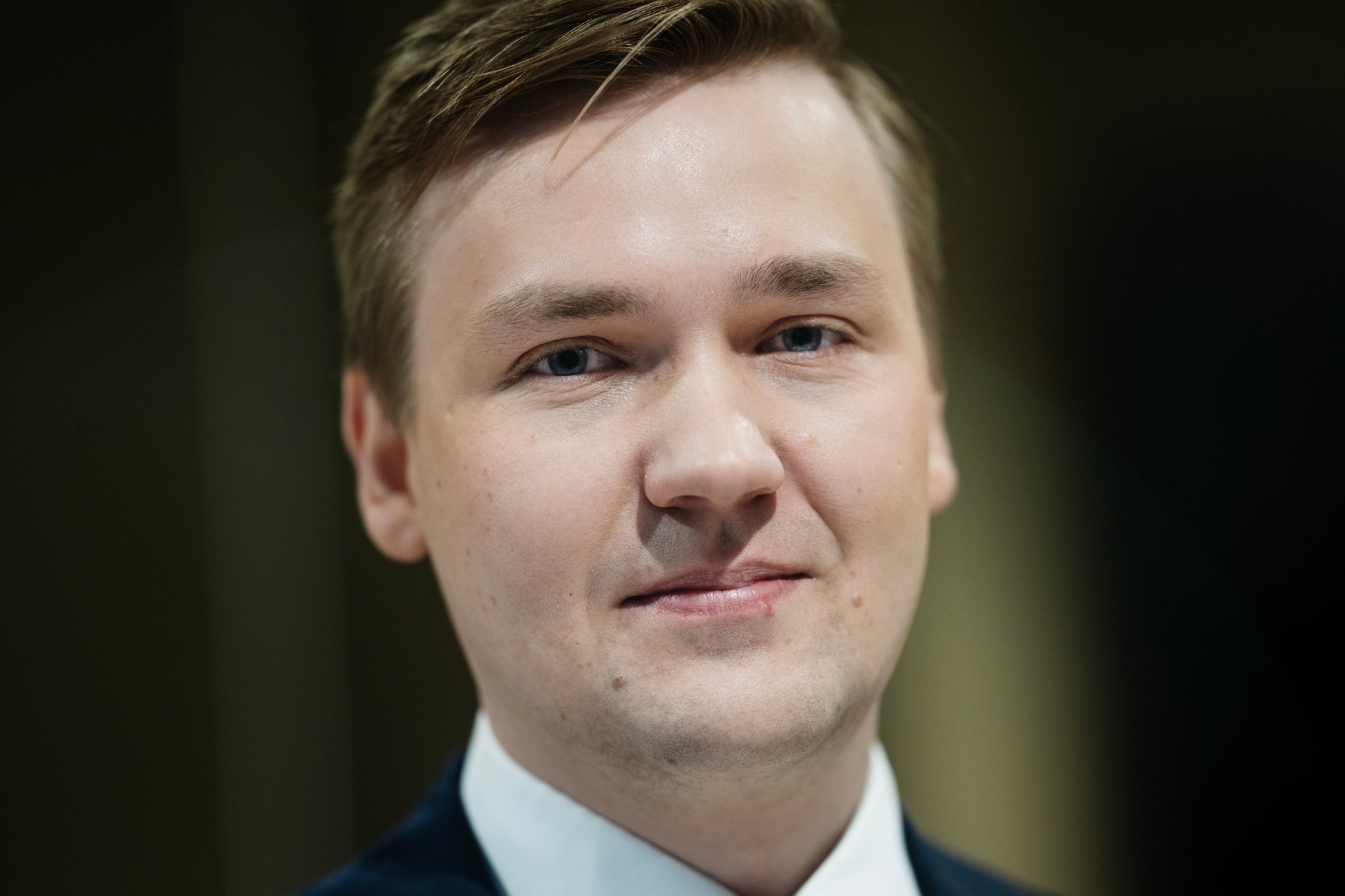 Porträttfoto av Herman Olsson, man i mörkblå kostym och ljusblå skjorta