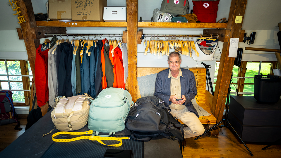 Martin Nordin sitter vid en mängd kläder från fjällräven. 