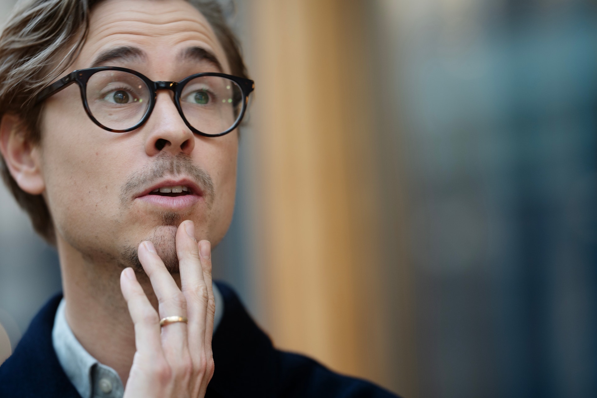 Man med glasögon i eftertänksam pose