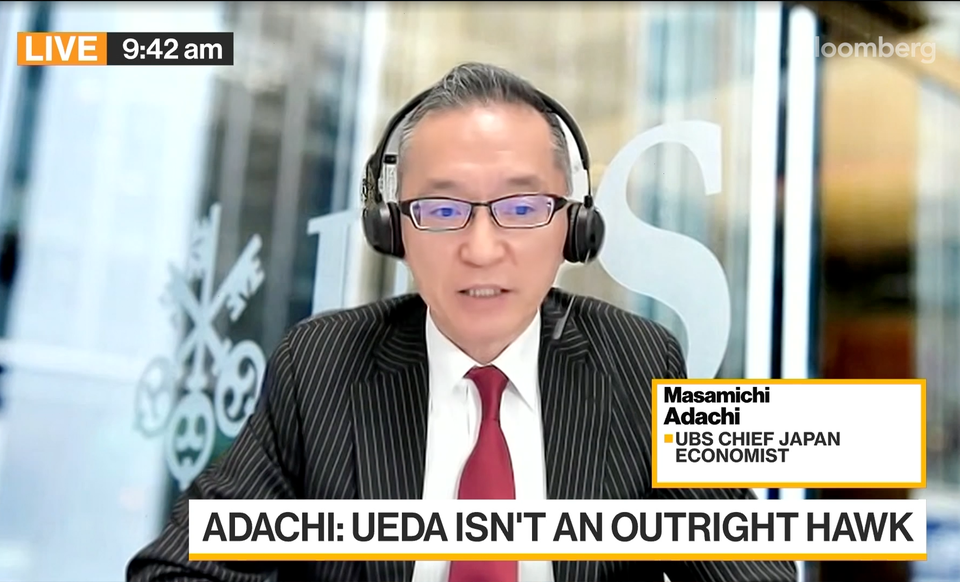 Man i kostym och glasögon med headset talar under en direktsänd intervju