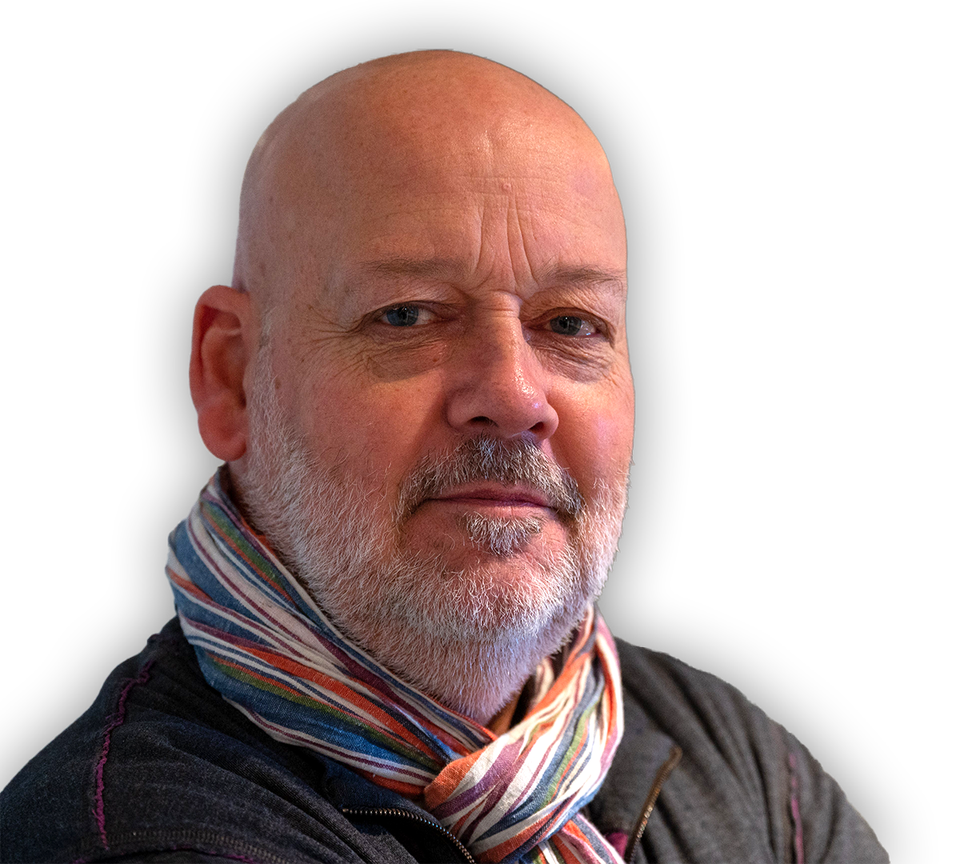 Joakim Friis i ett porträtt. Han bär färgglad scarf. 