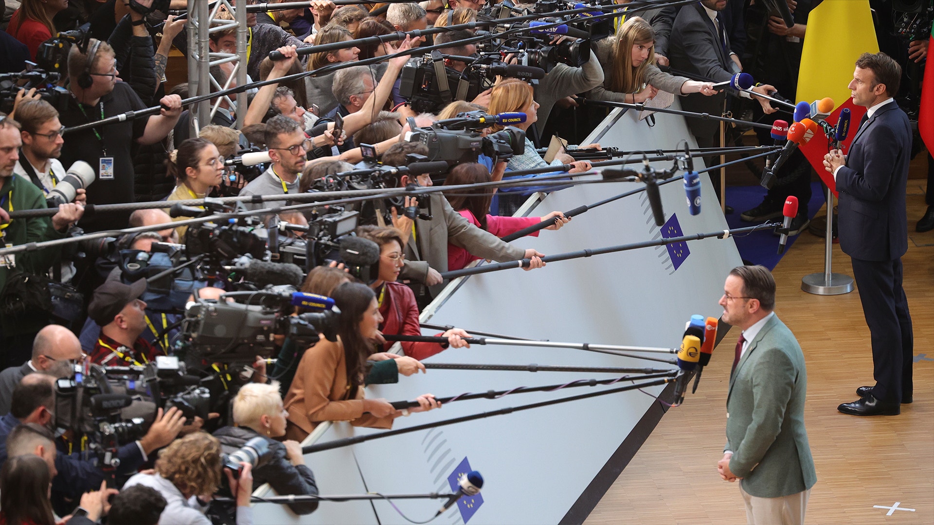 En presskonferens med många journalister, kameror och mikrofoner samlade runt en talare.