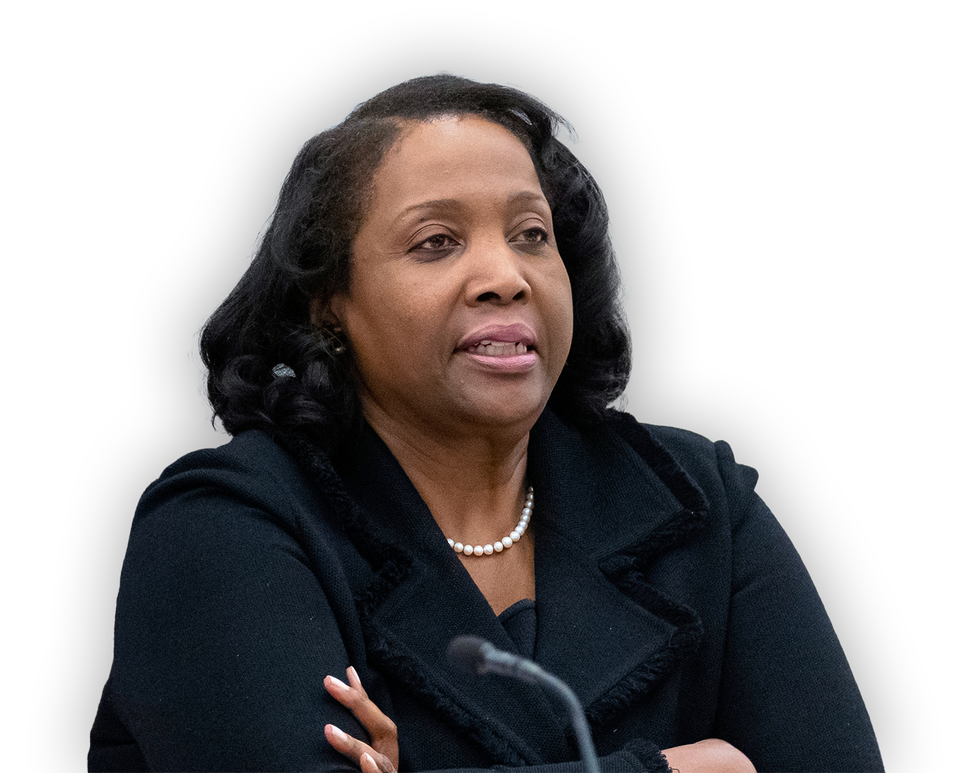 Lisa Cook sitter och pratar i centralbanken. Hon har svart kostym och pärlhalsband. 