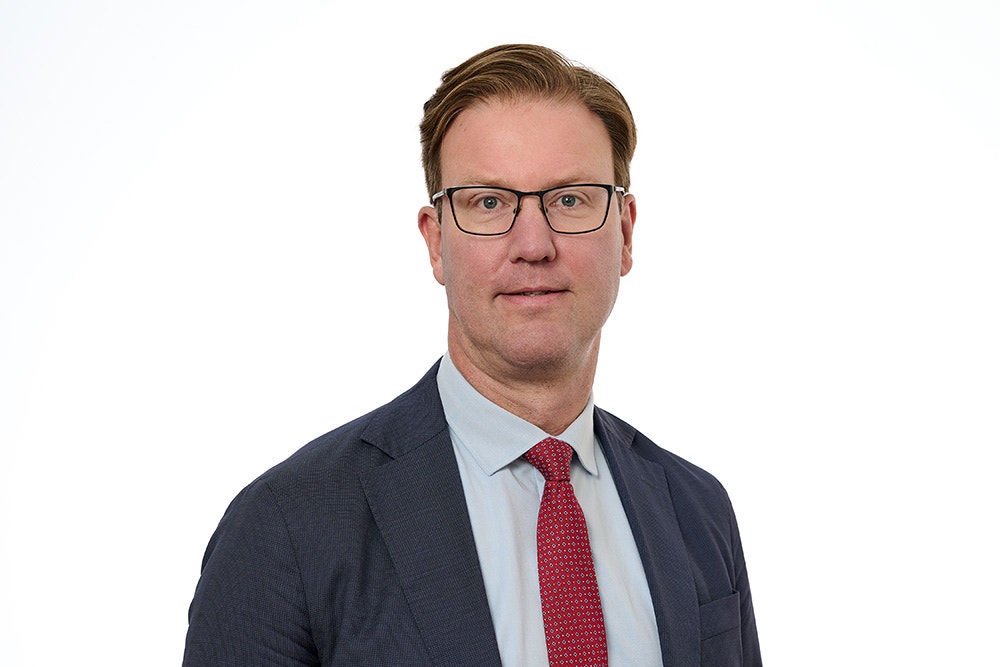 Porträtt av en man i affärskläder mot vit bakgrund