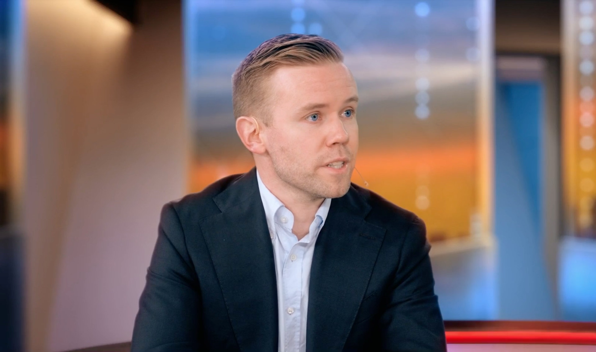 Man i kostym intervjuas i en tv-studio.