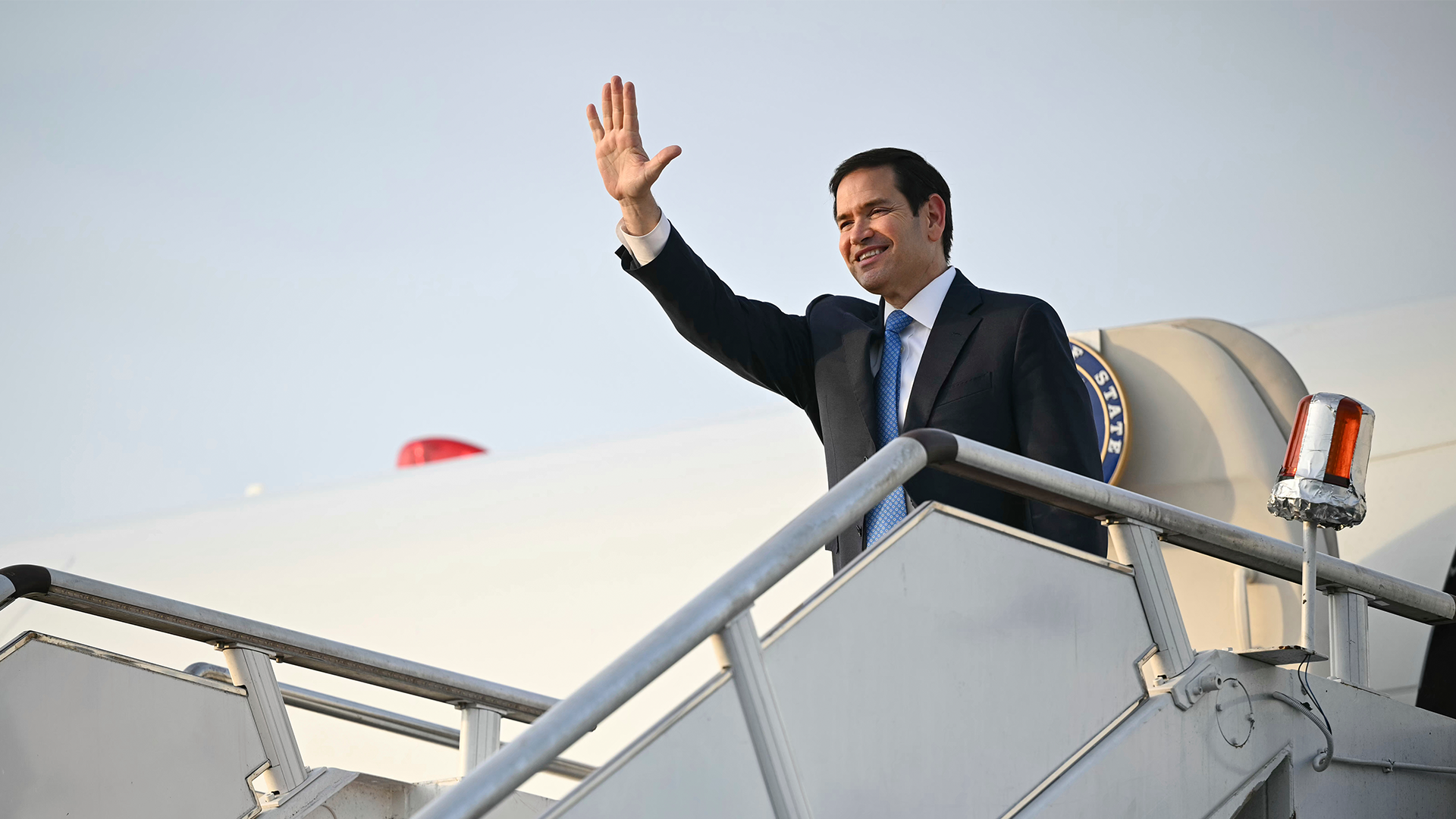 Marco Rubio vinkar när han ska gå ombord sin flygplan. 