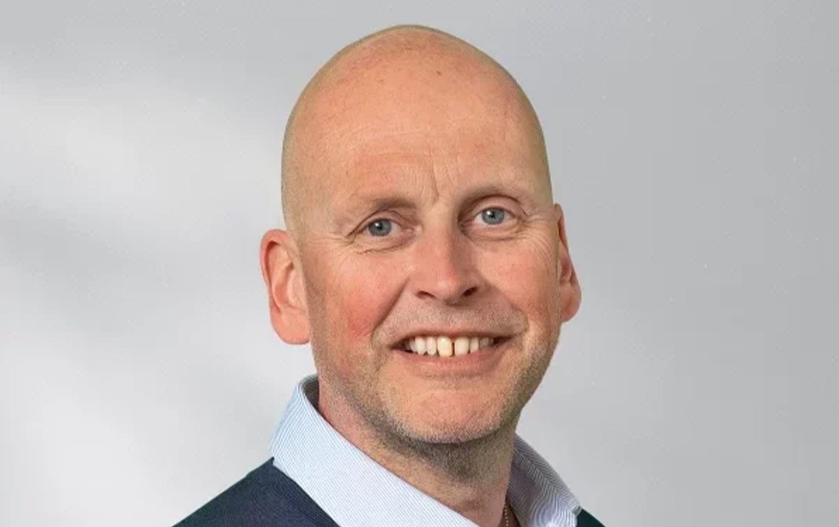 Porträttfoto av en man som ler mot kameran