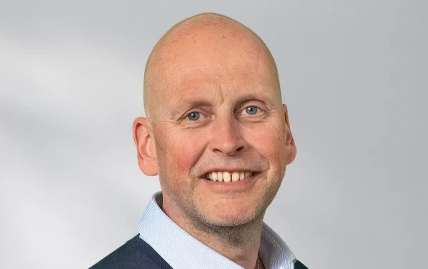 Porträttfoto av en man som ler mot kameran