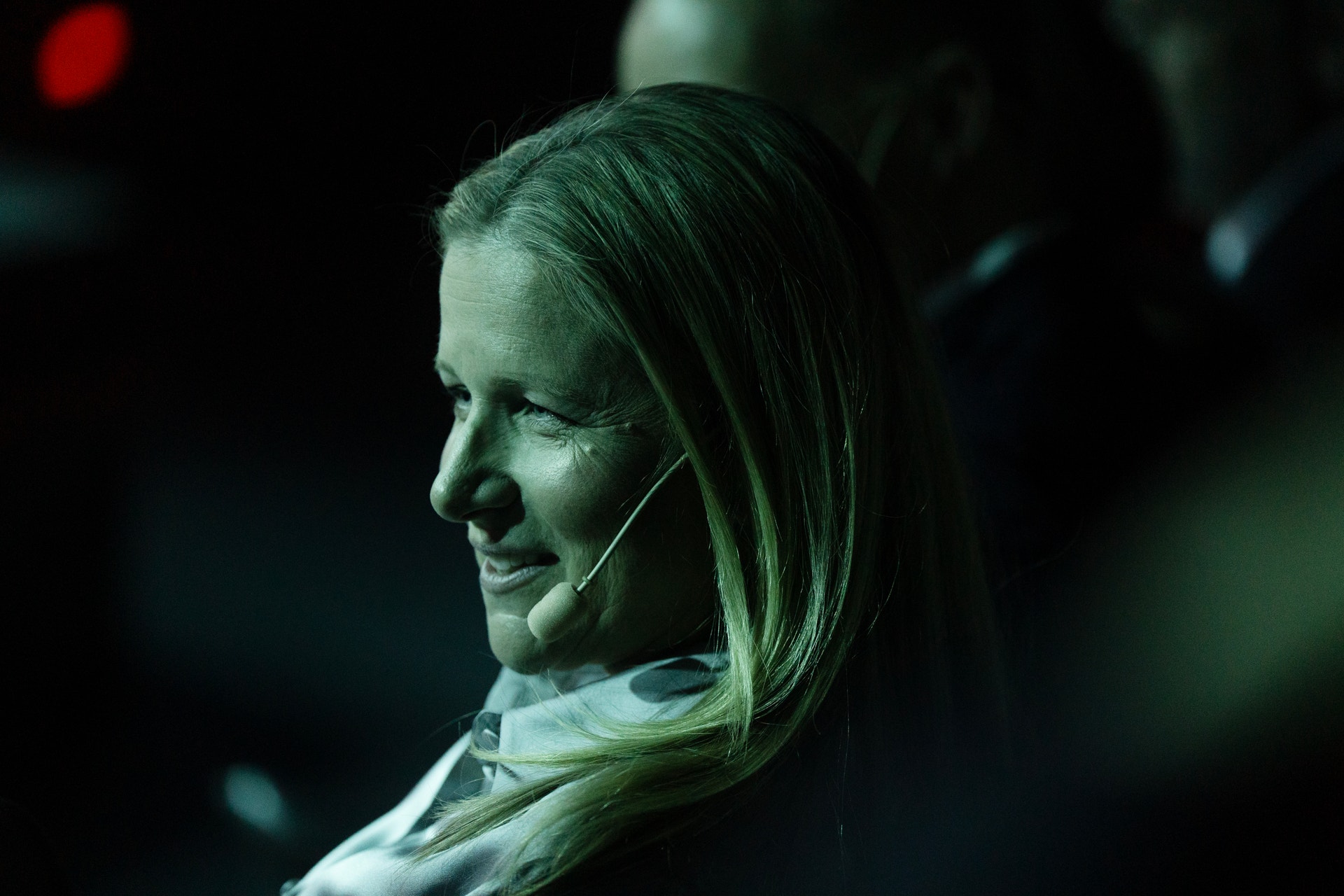 Kvinna i profil med headset-mikrofon på ett evenemang