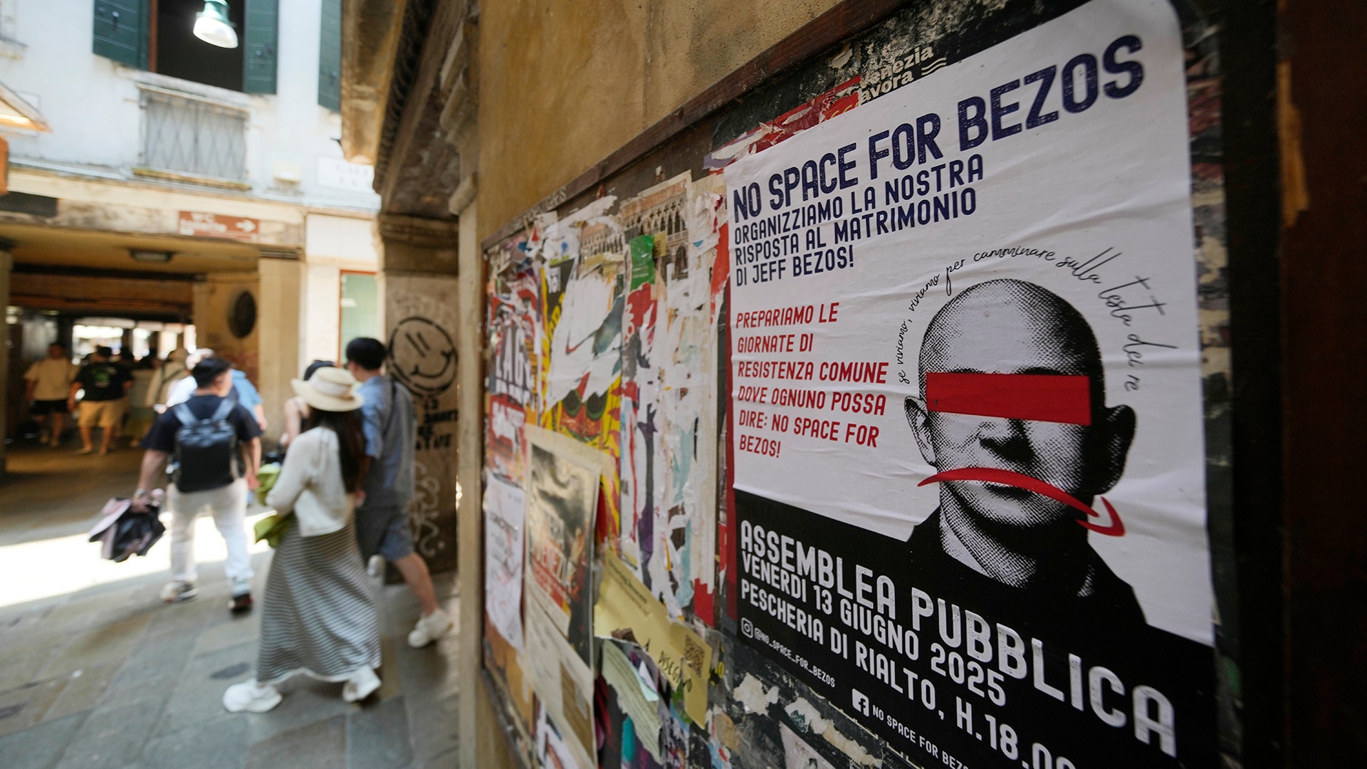 Affischer med texten "No space for Bezos" klär fasader i Venedig.