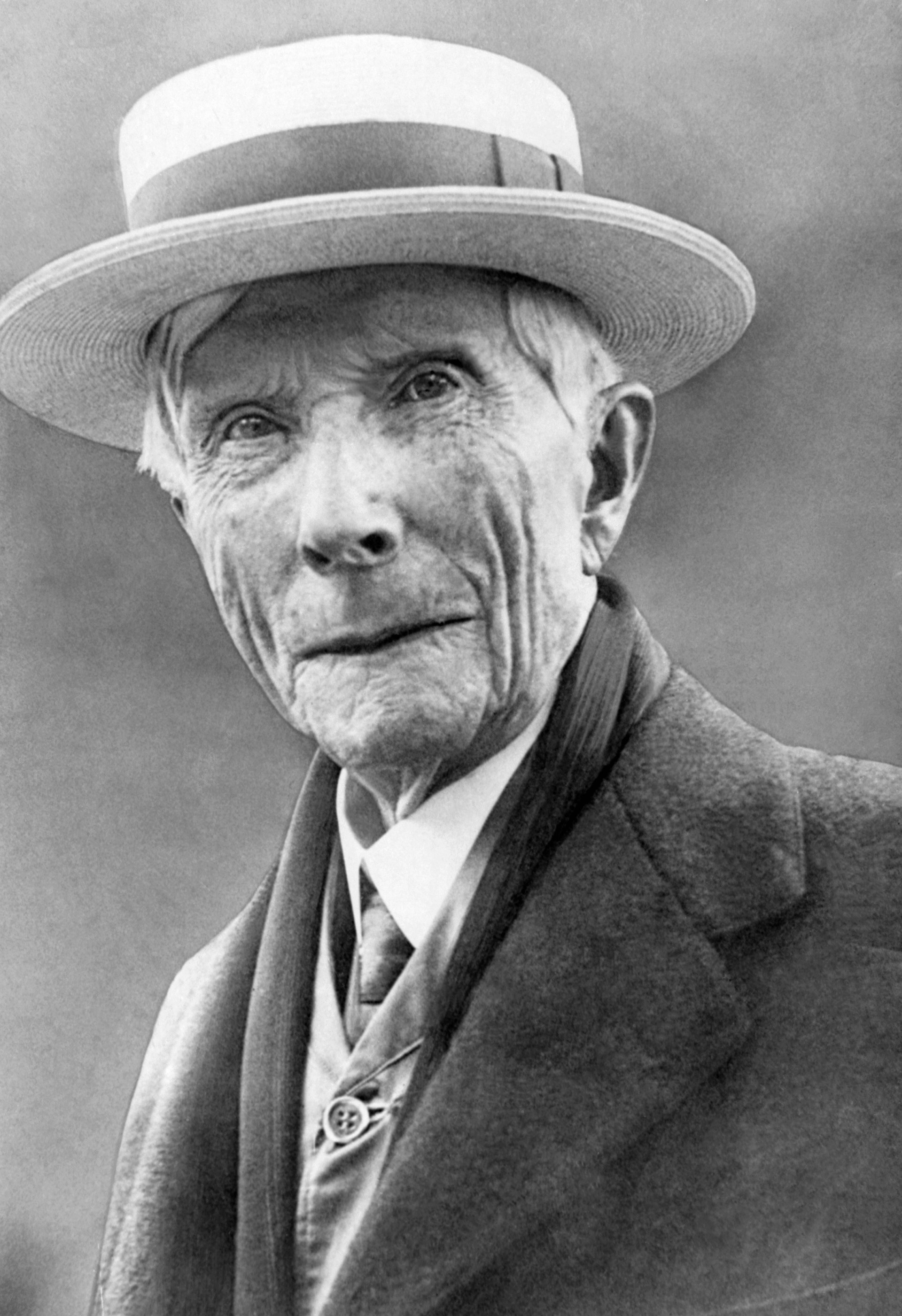 Svartvit porträttfoto av en äldre man från början av 1900-talet, klädd i formell kostym och hatt.