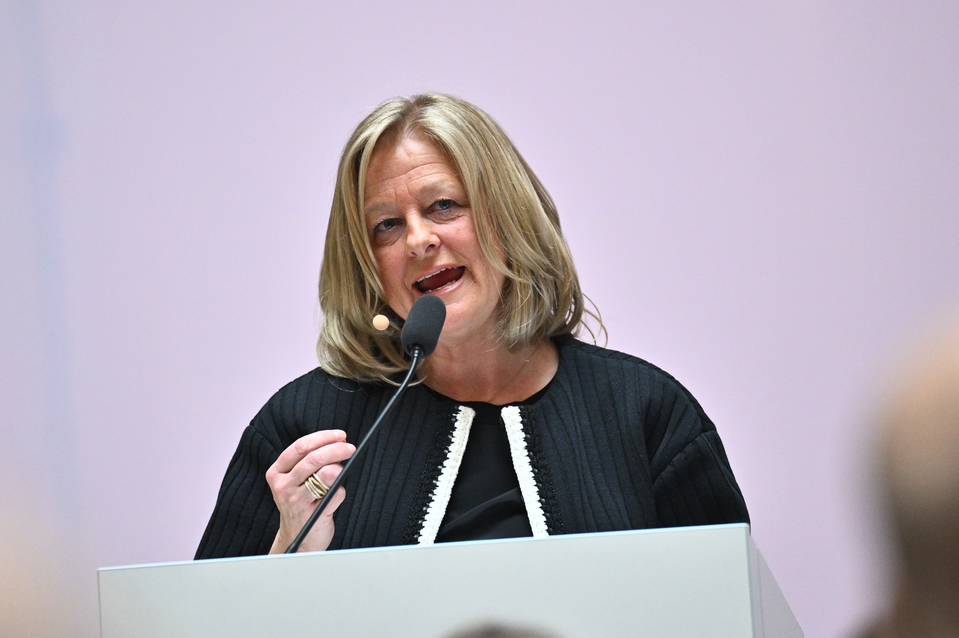 Kvinna talar vid ett podium med mikrofon
