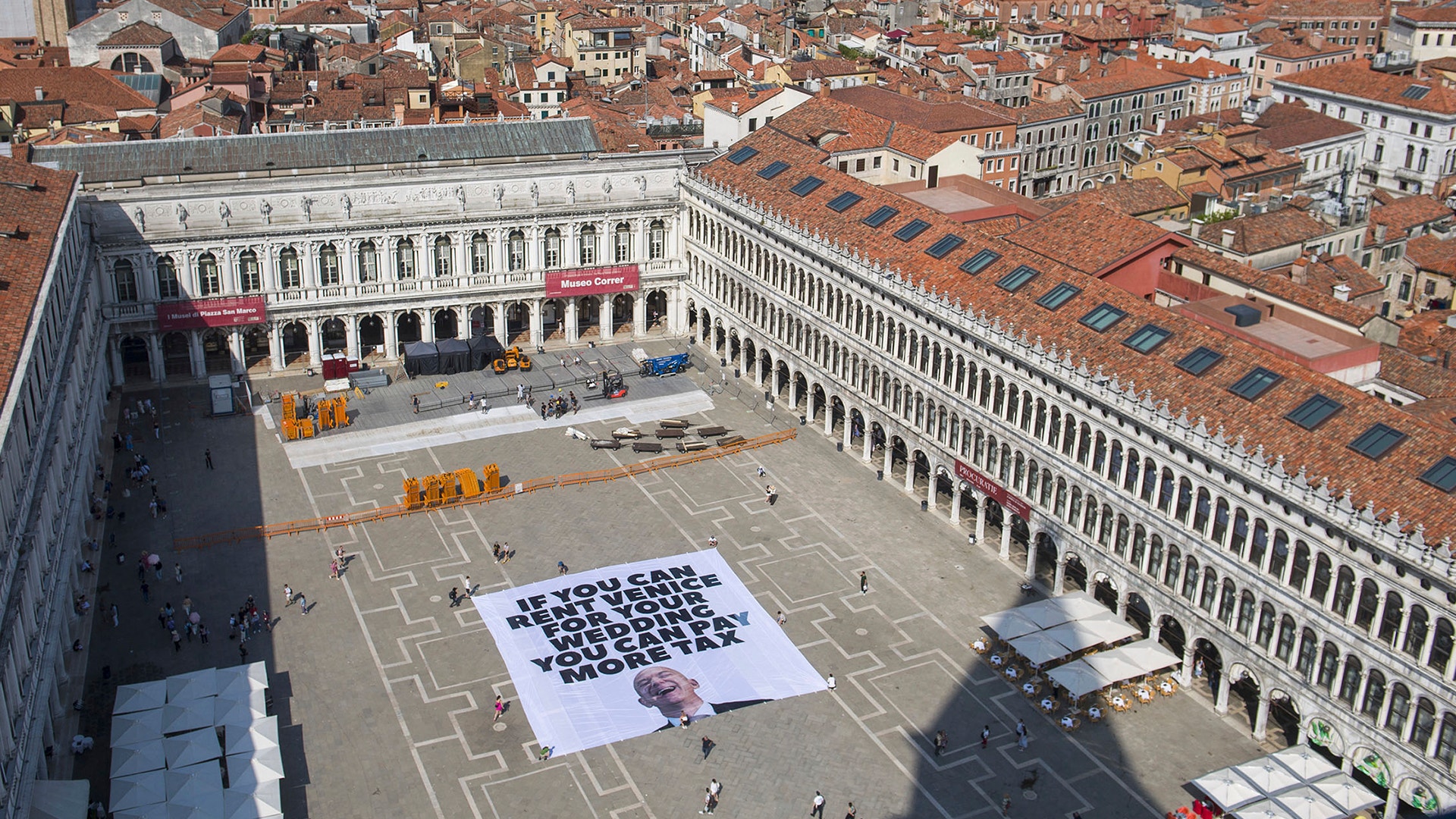 En banderoll på ett större torg i Venedig är riktat mot Jeff Bezos. På banderollen är det en bild på miljardären och en text som följer "If you can rent Venice for your wedding you can pay more tax".