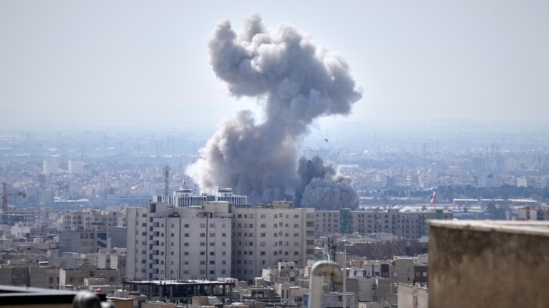 Stadsbild med rök som stiger från byggnader i en tätbefolkad stad