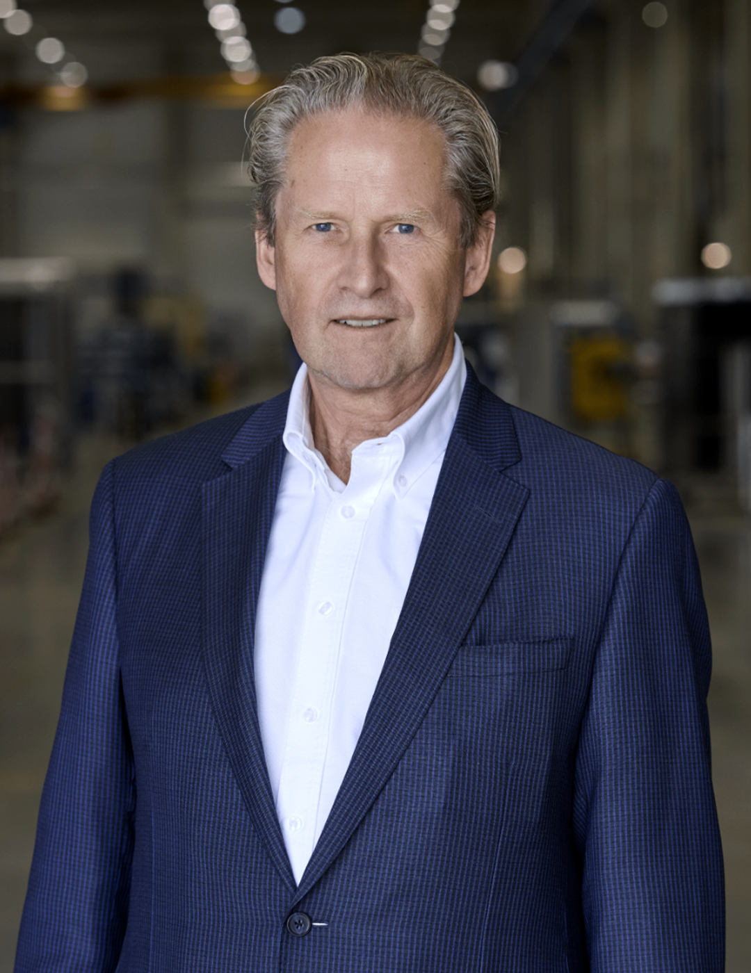 Porträttfoto av en man i mörkblå kostym och vit skjorta.