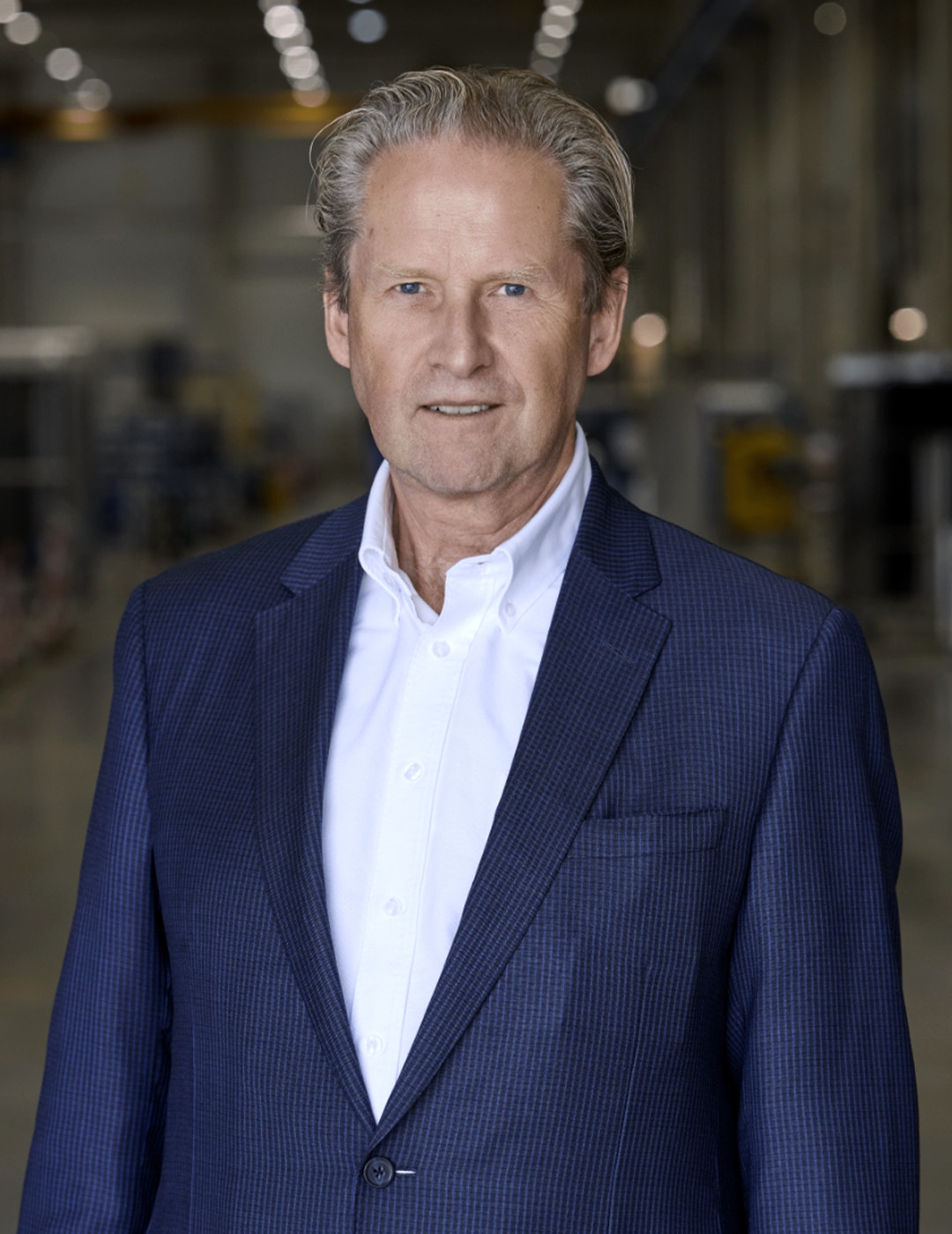 Porträttfoto av en man i mörkblå kostym och vit skjorta.