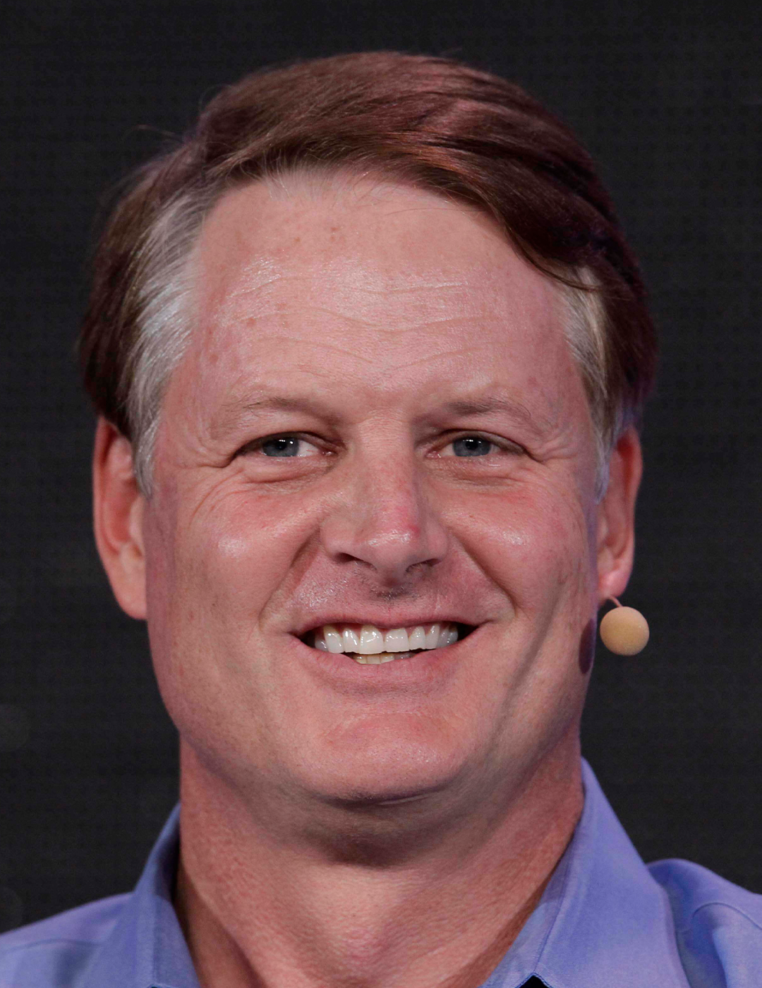 JOHN DONAHOE, Nikes tidigare vd, i blå skjorta. Han ler.