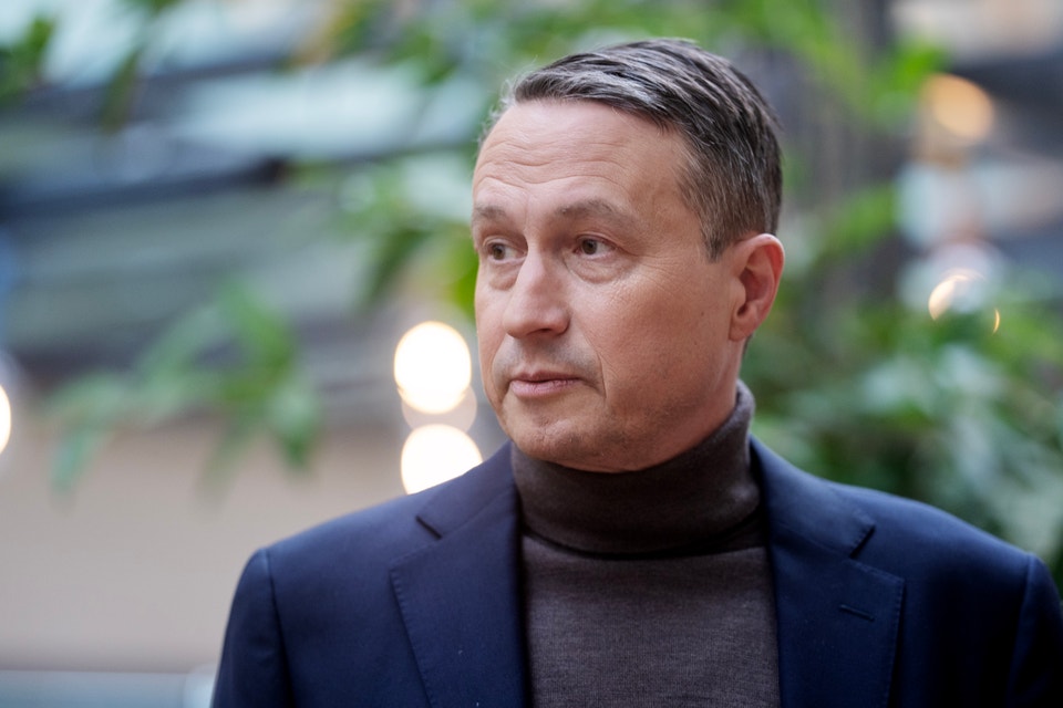 Porträtt av en man i mörkblå blazer och svart polotröja