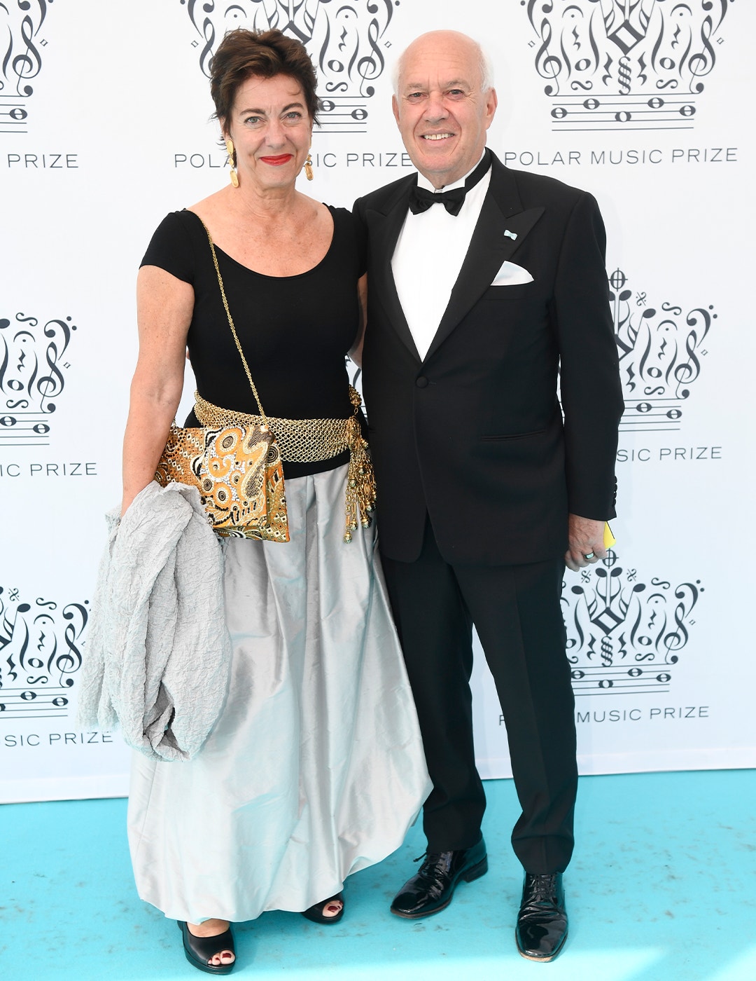 En man och en kvinna i formell klädsel står tillsammans framför en Polar Music Prize-bakgrund.