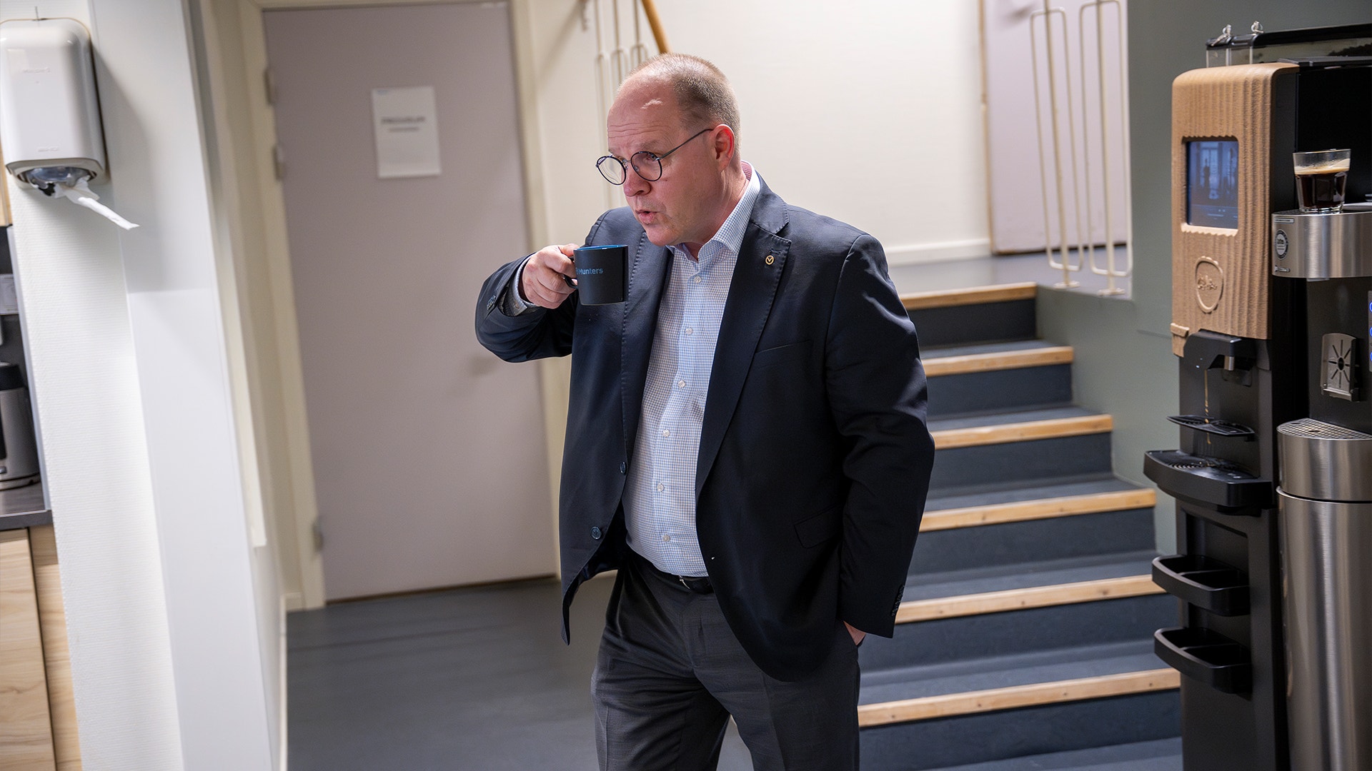  Klas Forsström i Munters fabrik. Han går genom personalavdelningen med en kopp kaffe i handen.