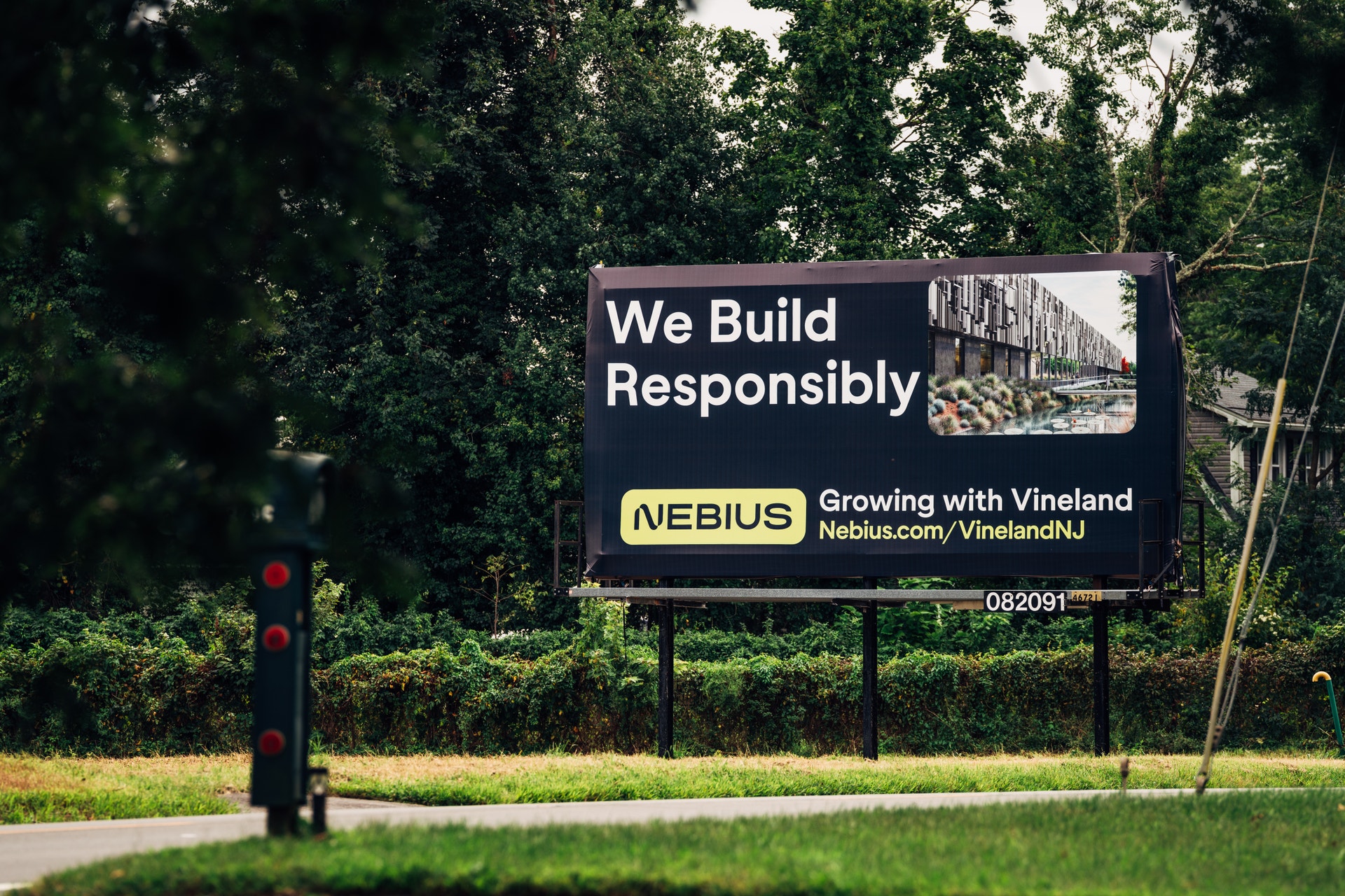 En reklamskylt vid vägkanten med texten "We Build Responsibly" och Nebius budskap om satsning i Vineland.
