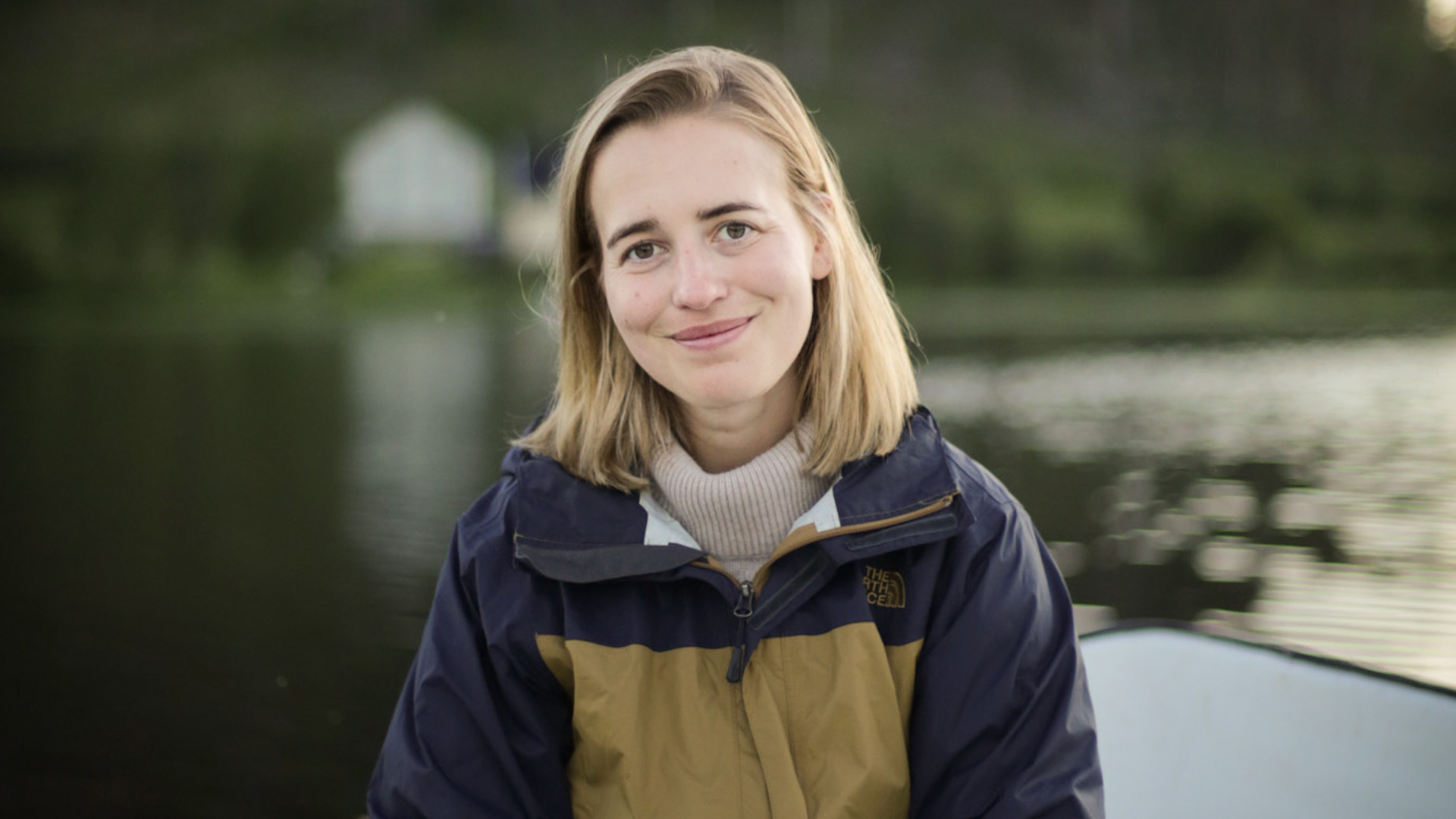 Jessica Backsell sitter och ler in i kameran på en båt i kvällsljus.