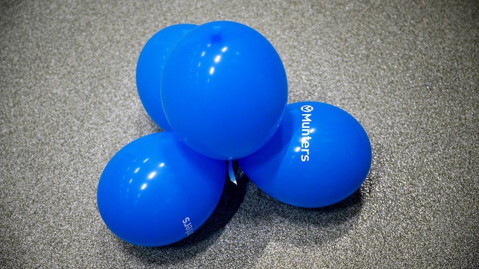 Ballonger med Munters logga är ihopsnörade i ett kluster.