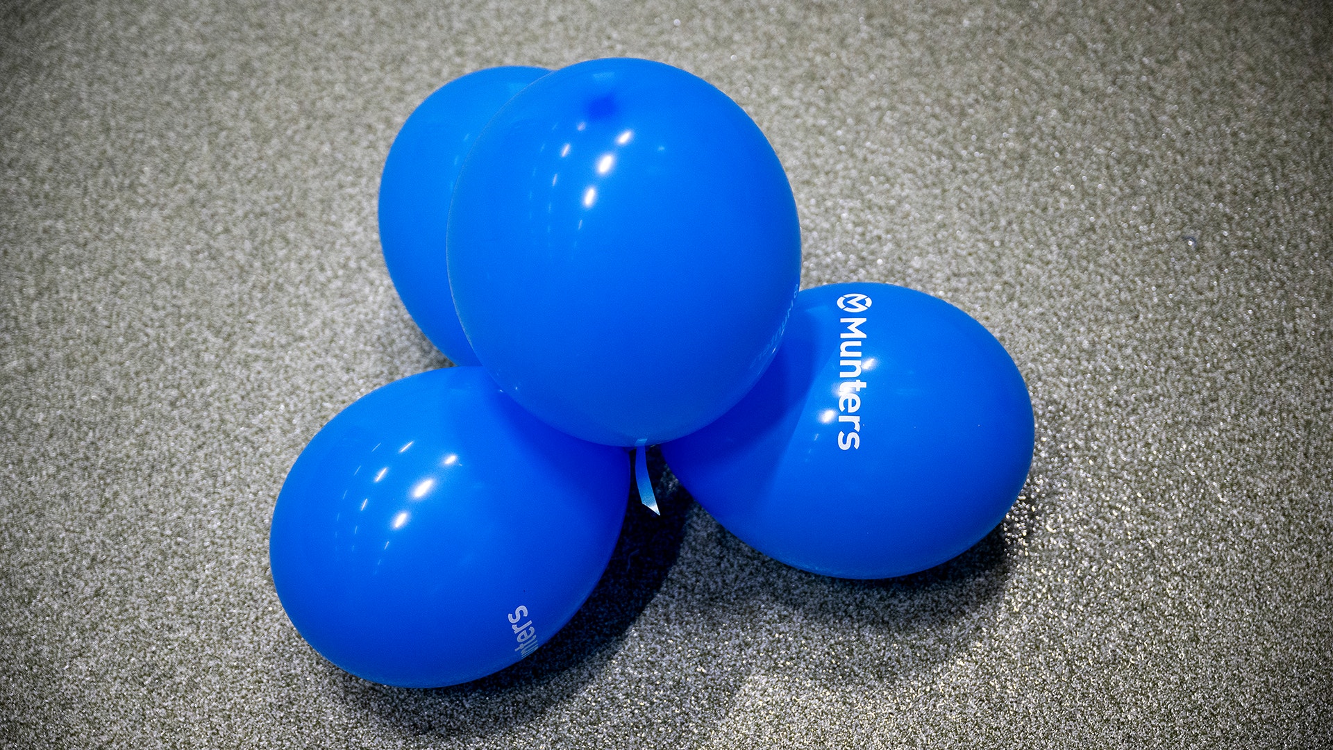 Ballonger med Munters logga är ihopsnörade i ett kluster.